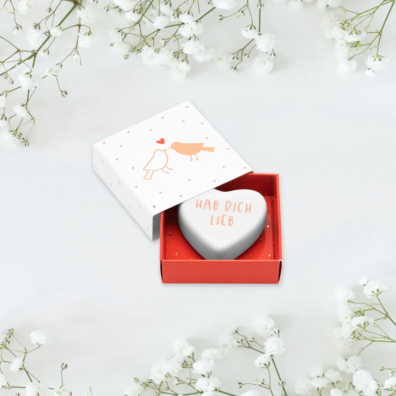 Weißes Porzellanherz mit der Aufschrift "Hab Dich lieb!" in einer Geschenkverpackung