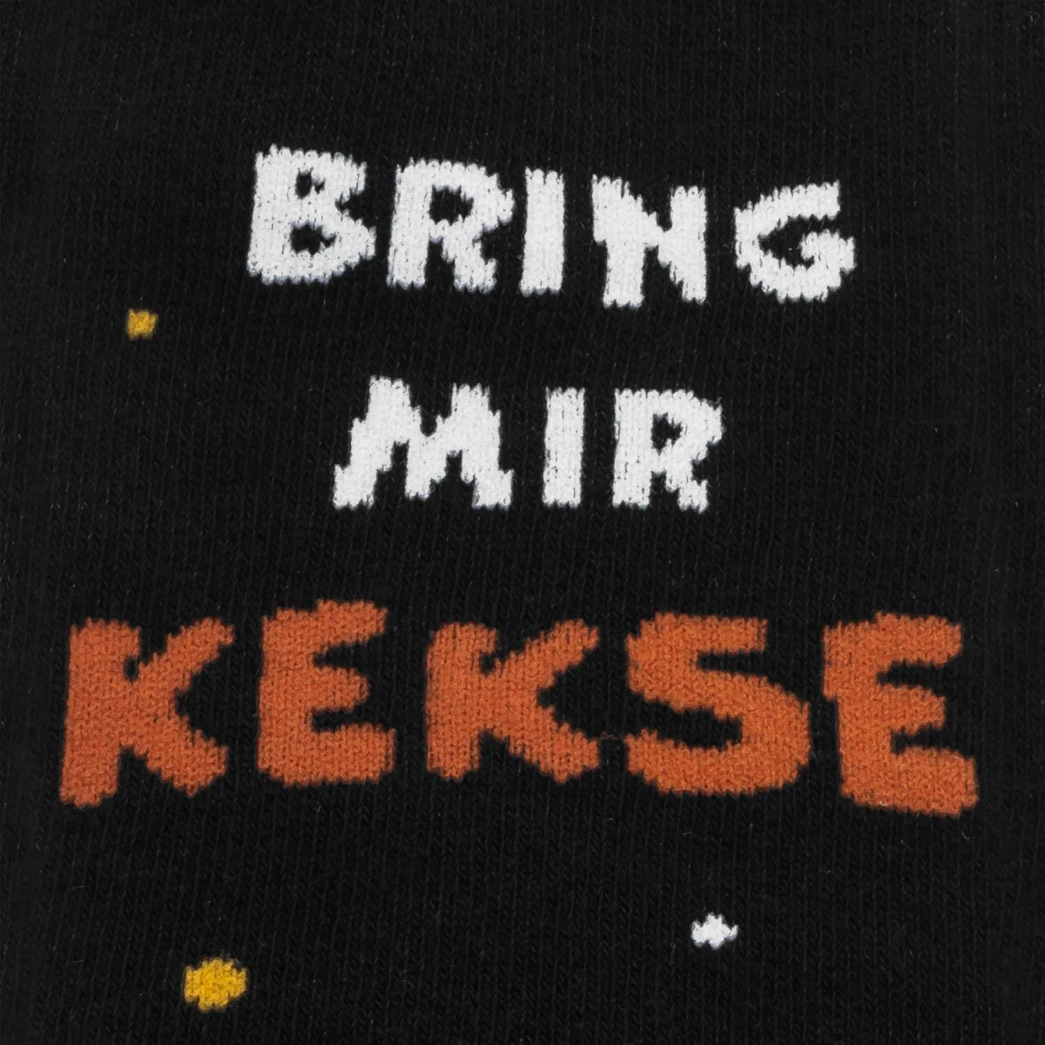 Schwarze Zaubersocken mit weißem Text BRING MIR und orange KEKSE, verziert mit buntem Konfetti.