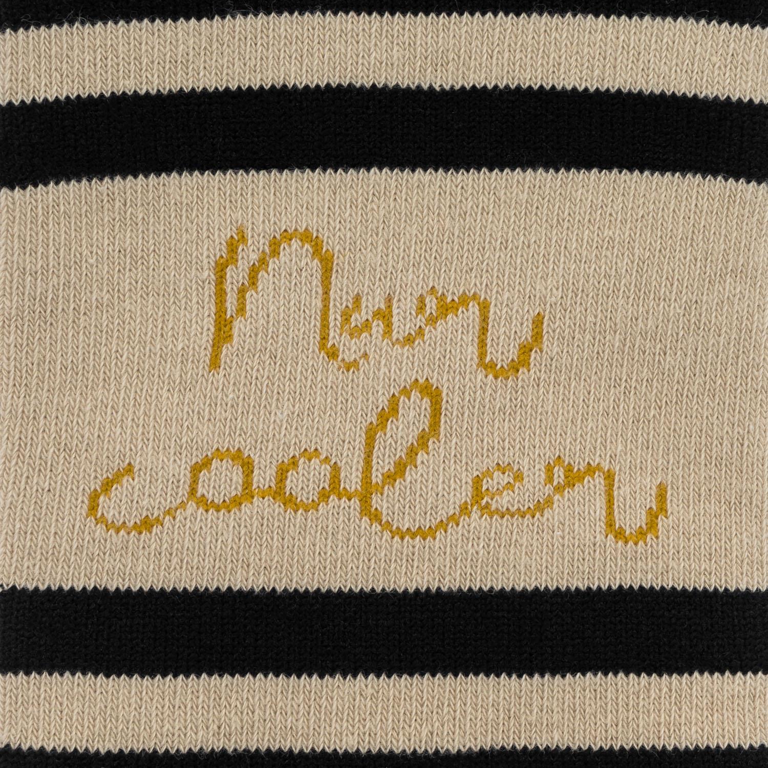 Beigefarbene Zaubersocken mit schwarzer Streifenleiste und goldfarbenem Schriftzug Ente.