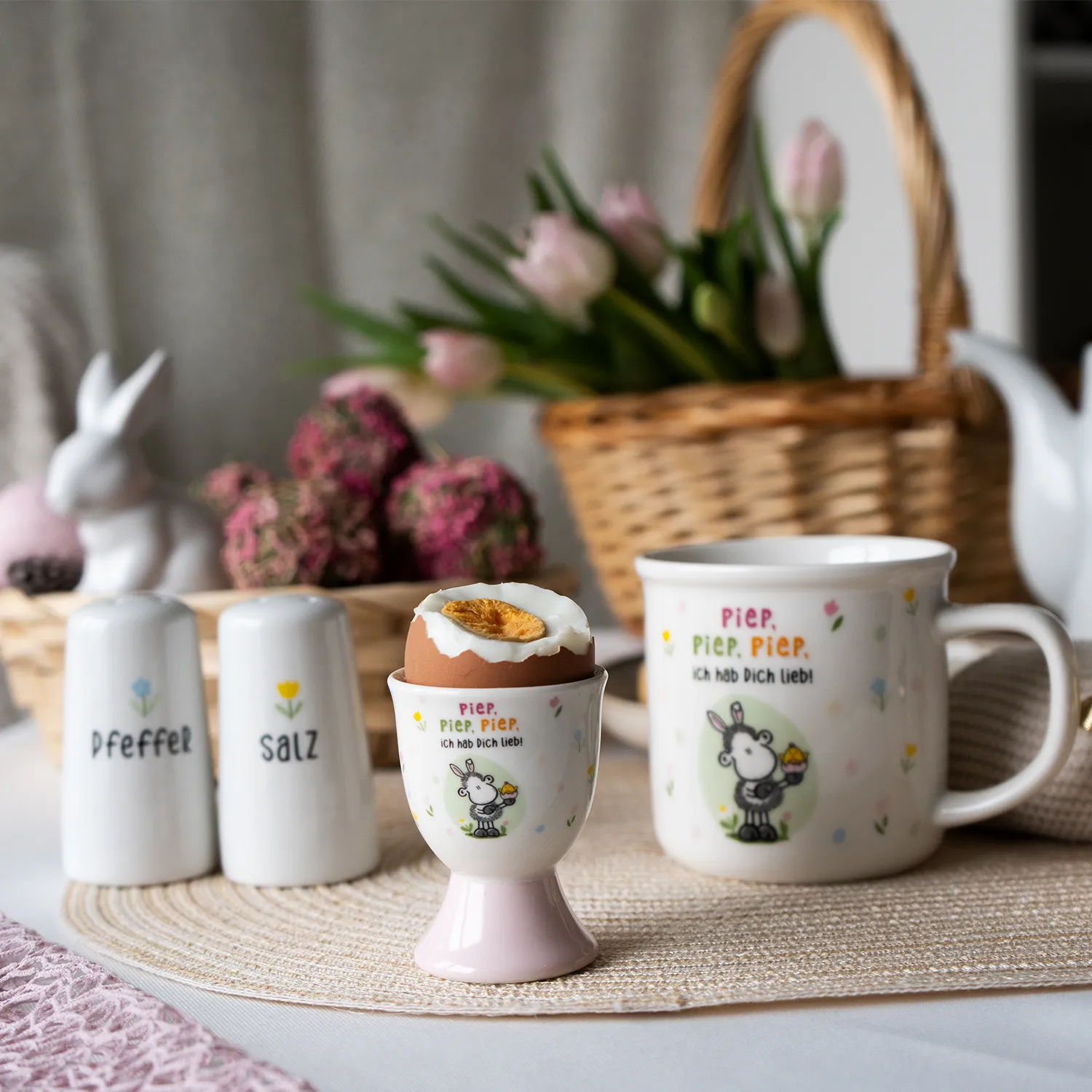 Eierbecher aus Porzellan mit Schäfchen-Motiv in Pastellfarben.