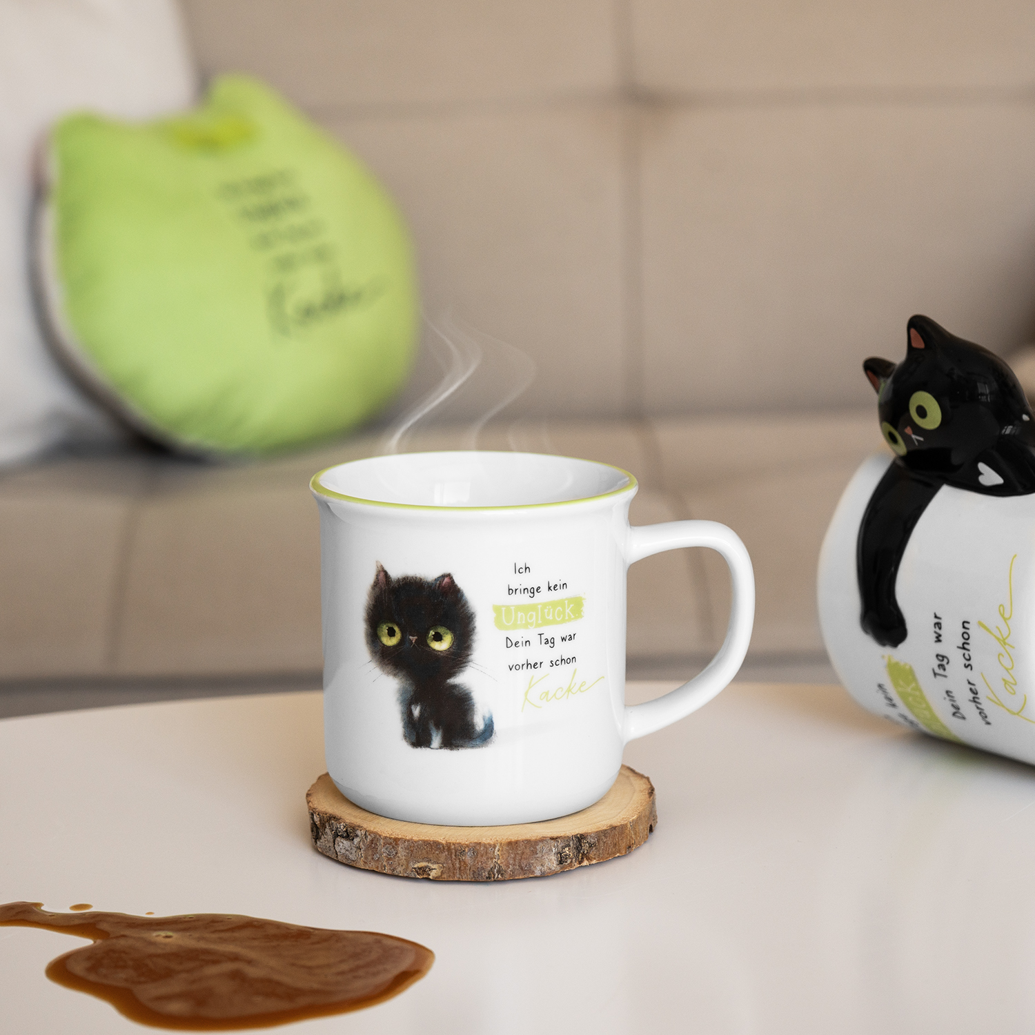 Becher »schwarze Katze« – weiße Keramik mit schwarzem Katzendruck und grünem Rand.
