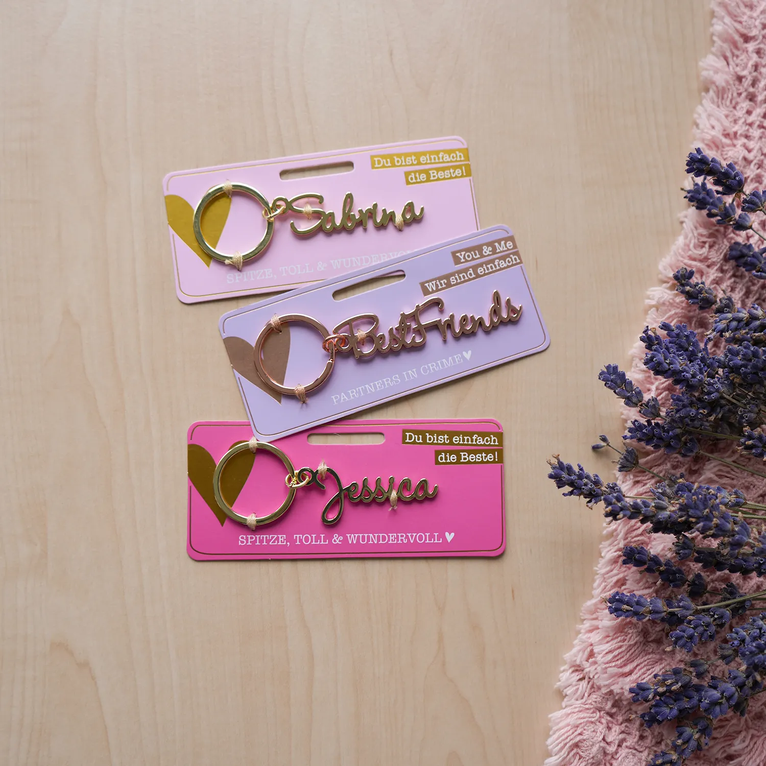 Namens-Schlüsselanhänger aus Metall mit individuellem Schriftzug und Schlüsselring auf pastellfarbiger Headerkarte