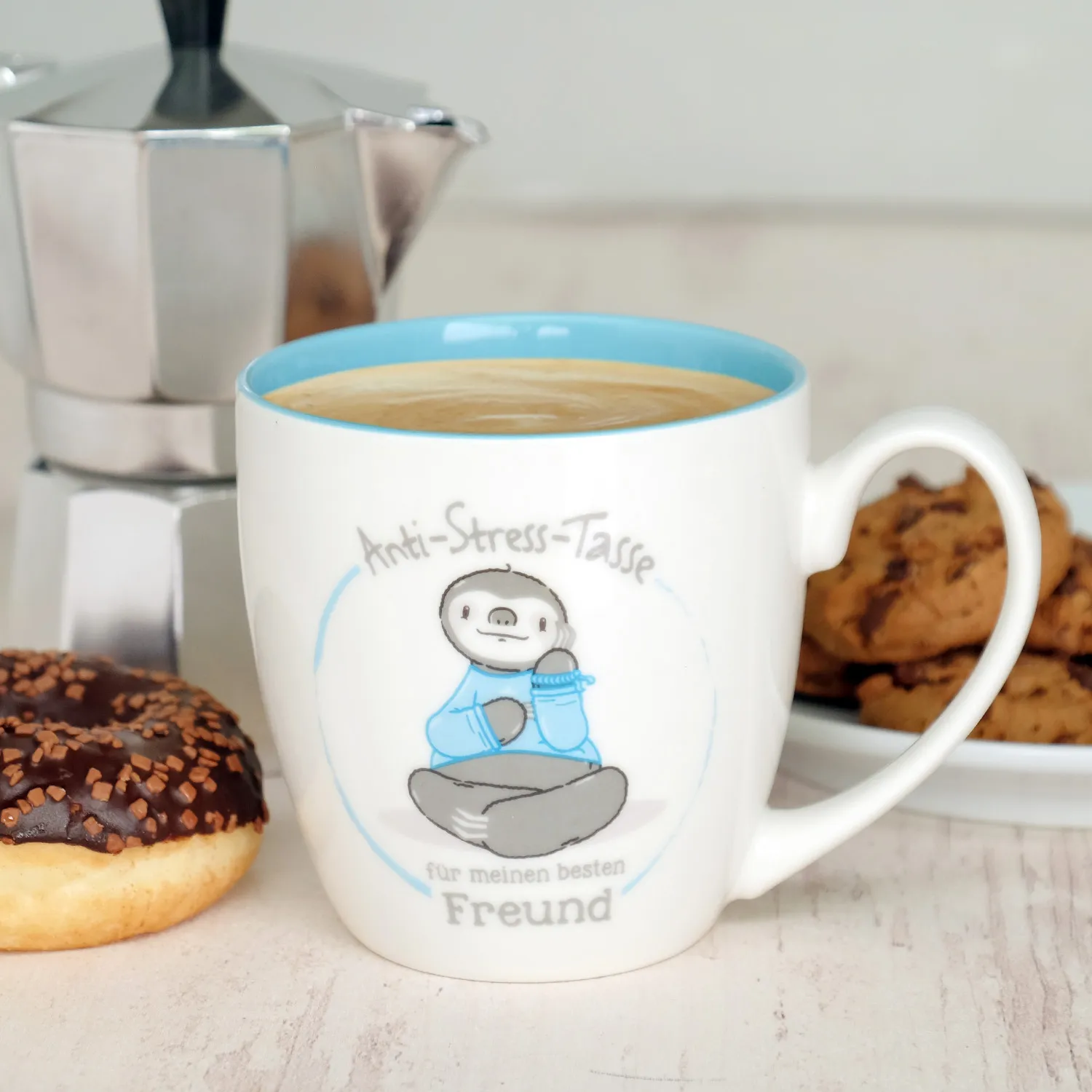Weiße Porzellan-Tasse mit hellblauem Innenrand und Anti-Stress-Motiv.