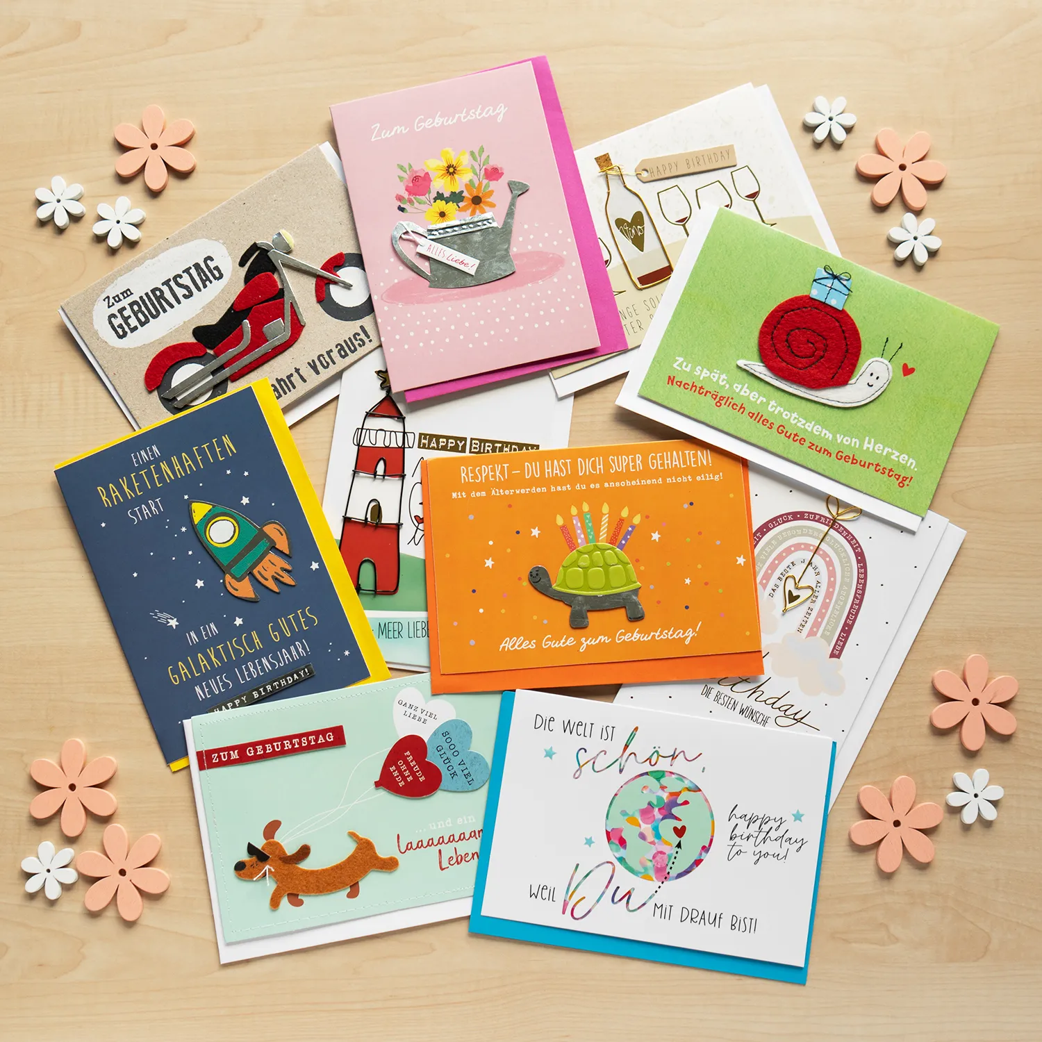 Bunte Geburtstagskarten im Set mit Umschlägen auf Holztisch.