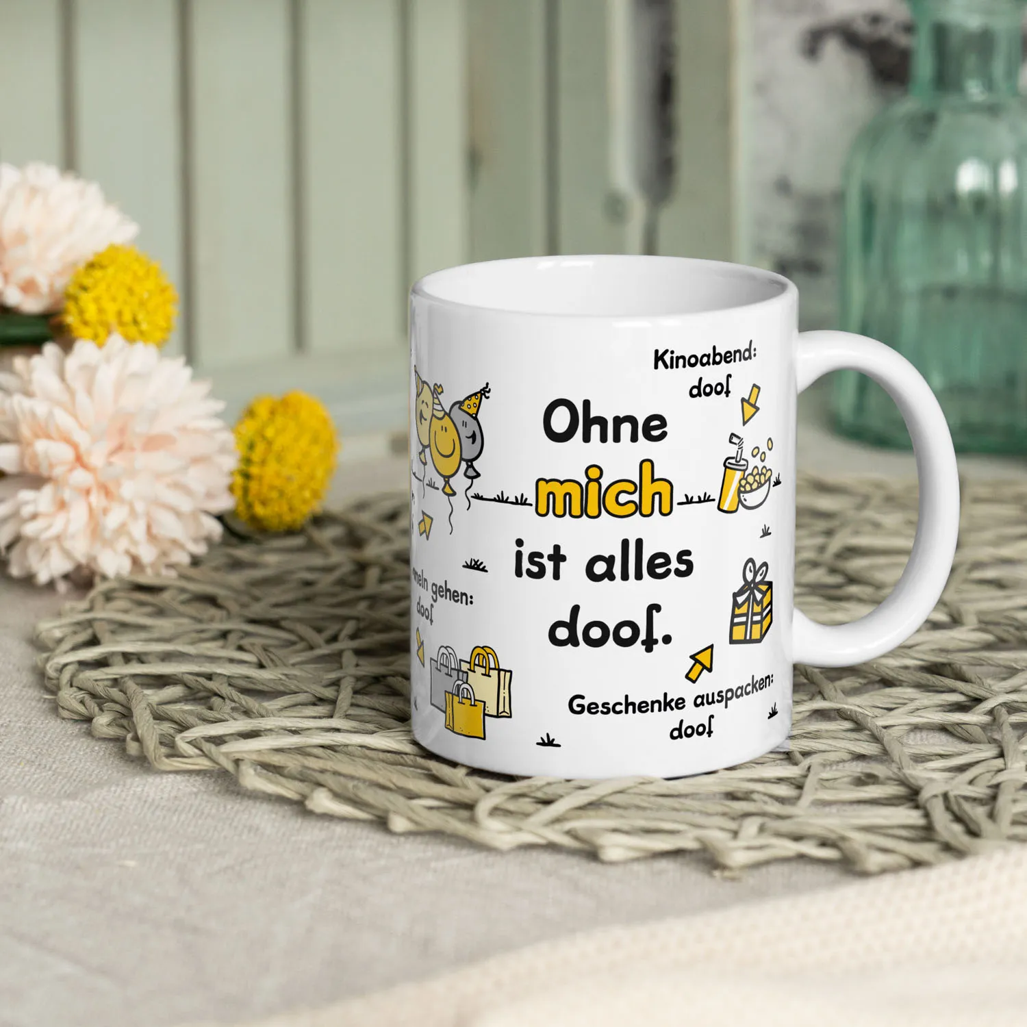 Weiße Porzellan-Tasse mit Spruch 'Ohne mich ist alles doof' und gelben Akzenten.