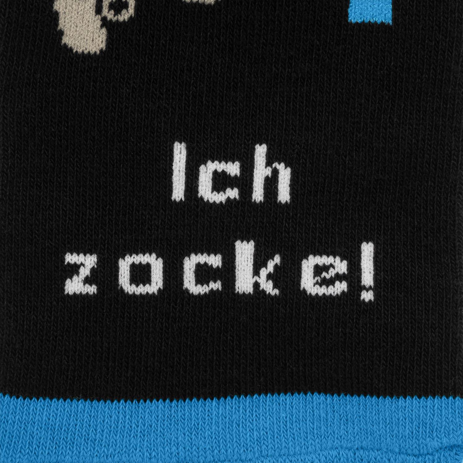 Schwarze Socke mit weißem Aufdruck 'Ich zocke!' und blauem Bündchen