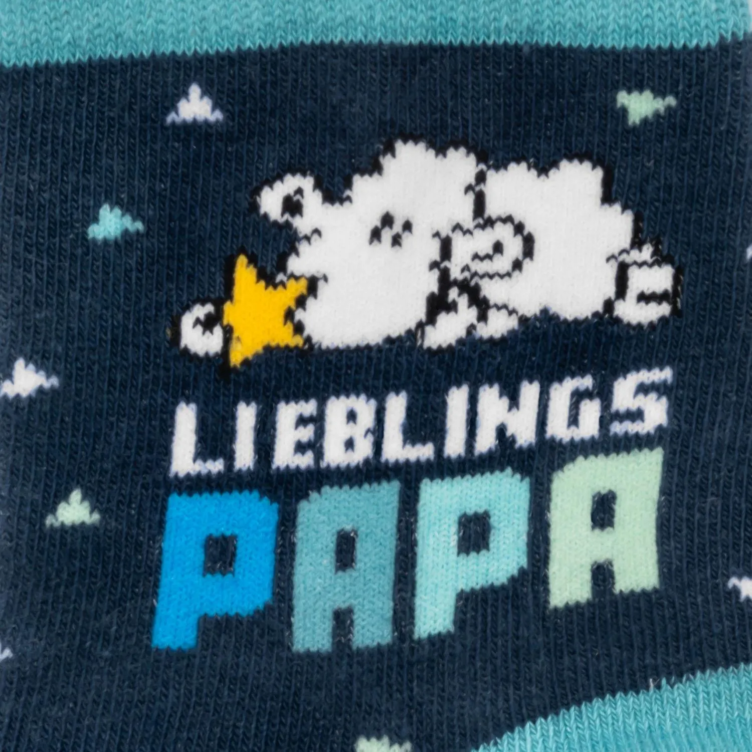 Zaubersocken mit dunkelblauem Hintergrund, buntem Schriftzug 'Lieblings Papa' und Wolkenmotiven.