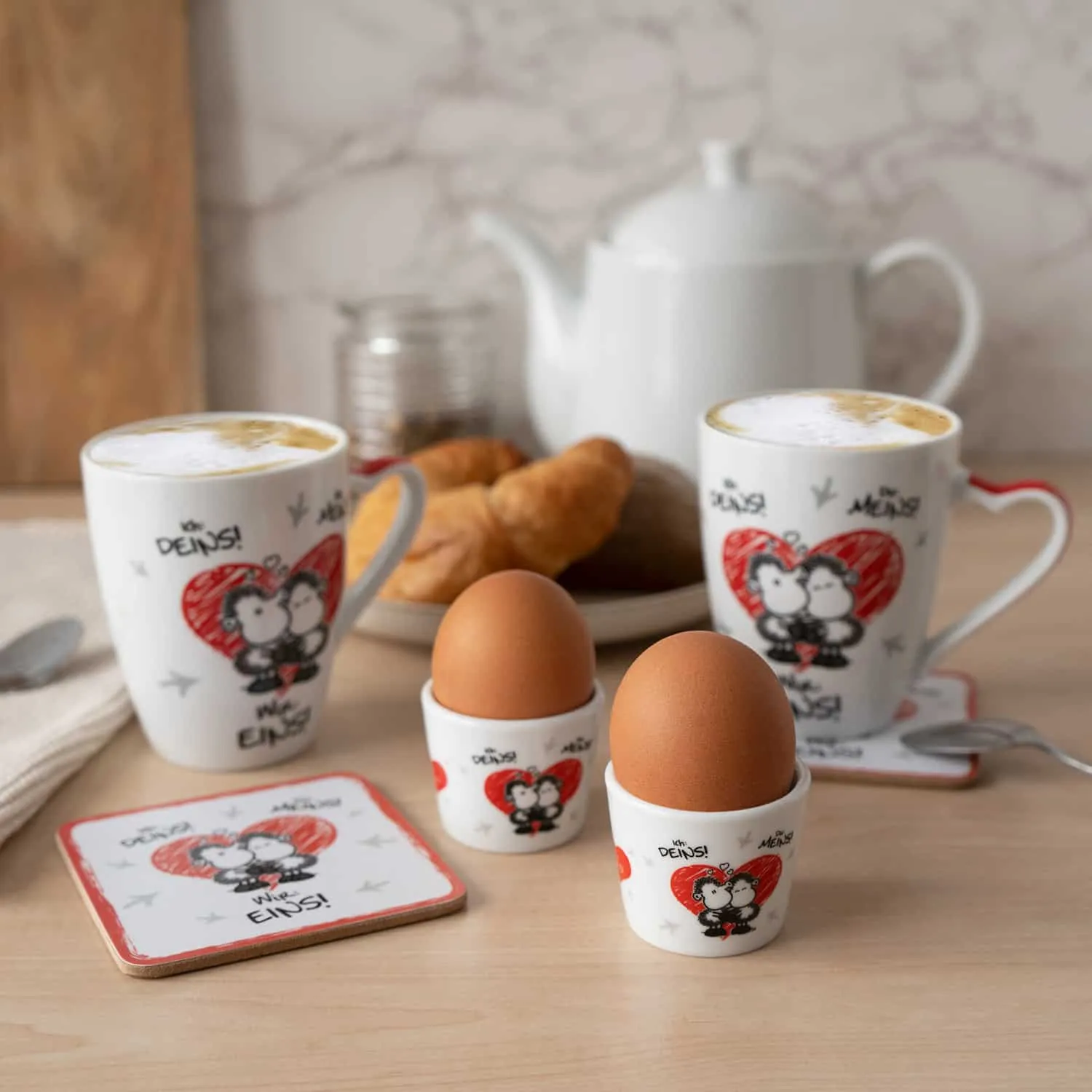 Geschenkset bestehend aus zwei Tassen, zwei Eierbechern und zwei Untersetzern