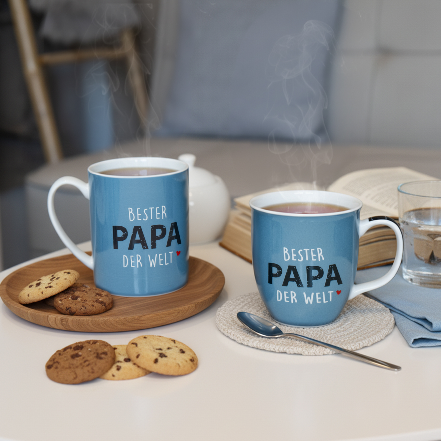 Blaue Porzellan-Tassen mit weißem Innenraum und Aufdruck 'BESTER PAPA DER WELT'.