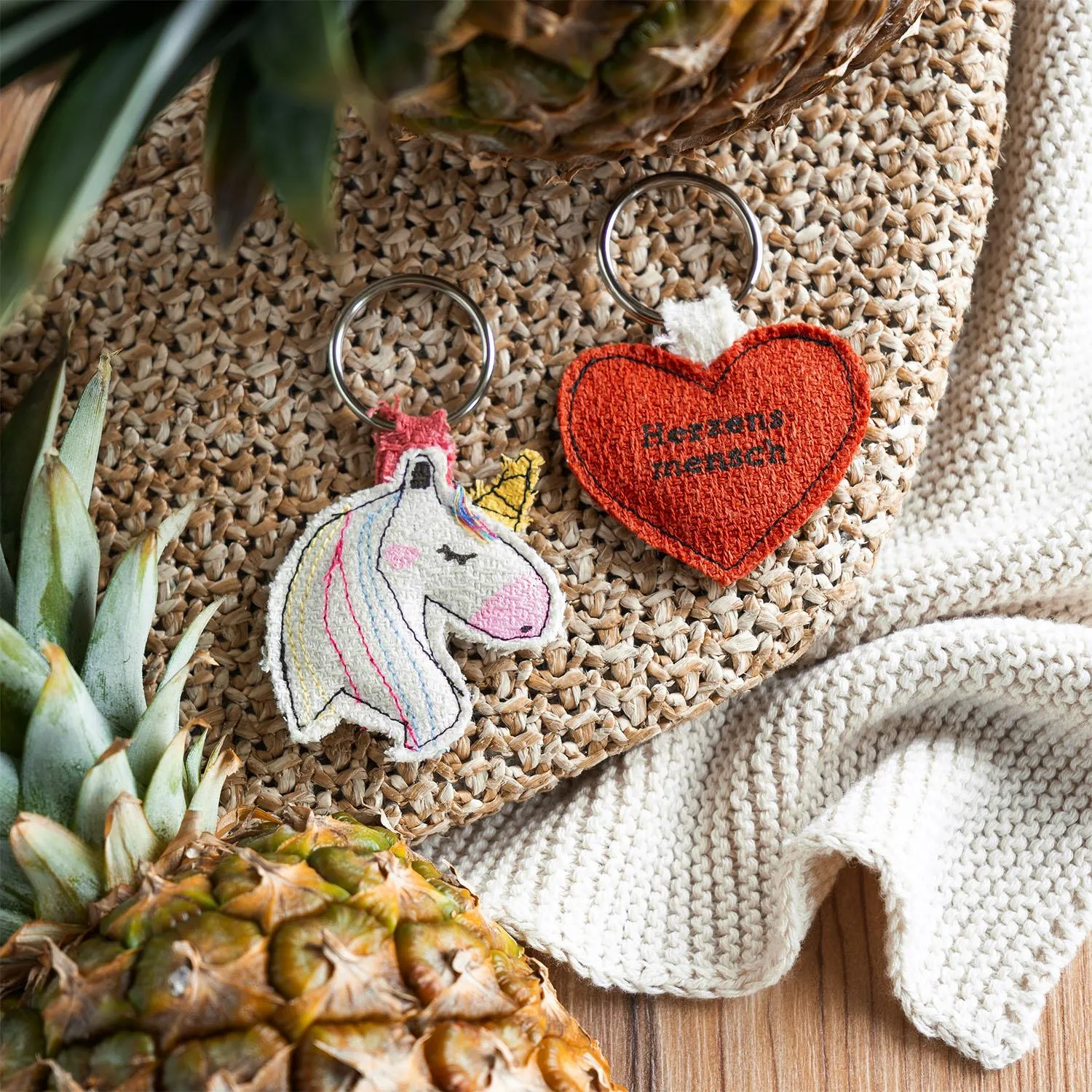 Einhorn-Schlüsselanhänger mit bunter Mähne und rotem Herz aus Ananasblattfaser, Baumwolle und Metall.