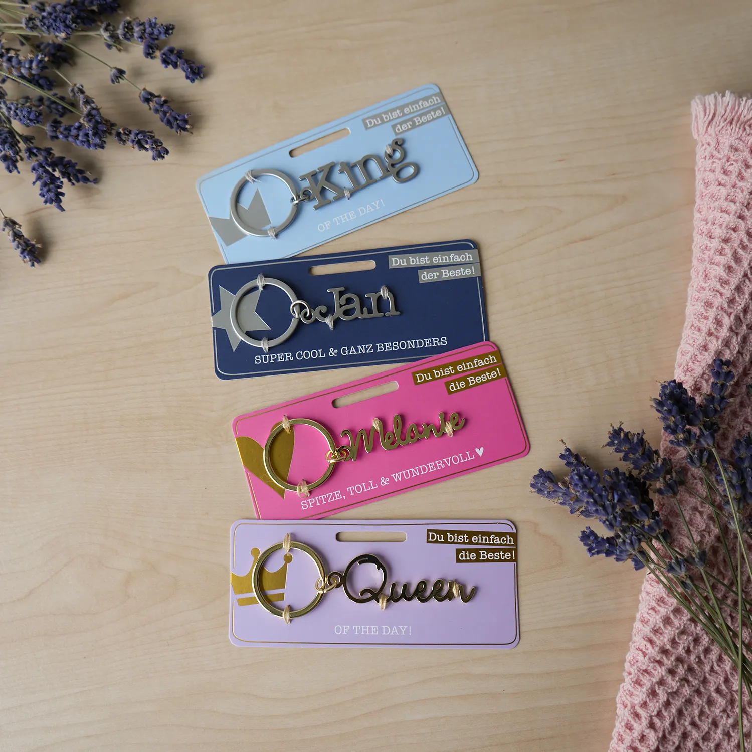 Personalisierter Namens-Schlüsselanhänger aus Edelstahl auf Pastellkarten.