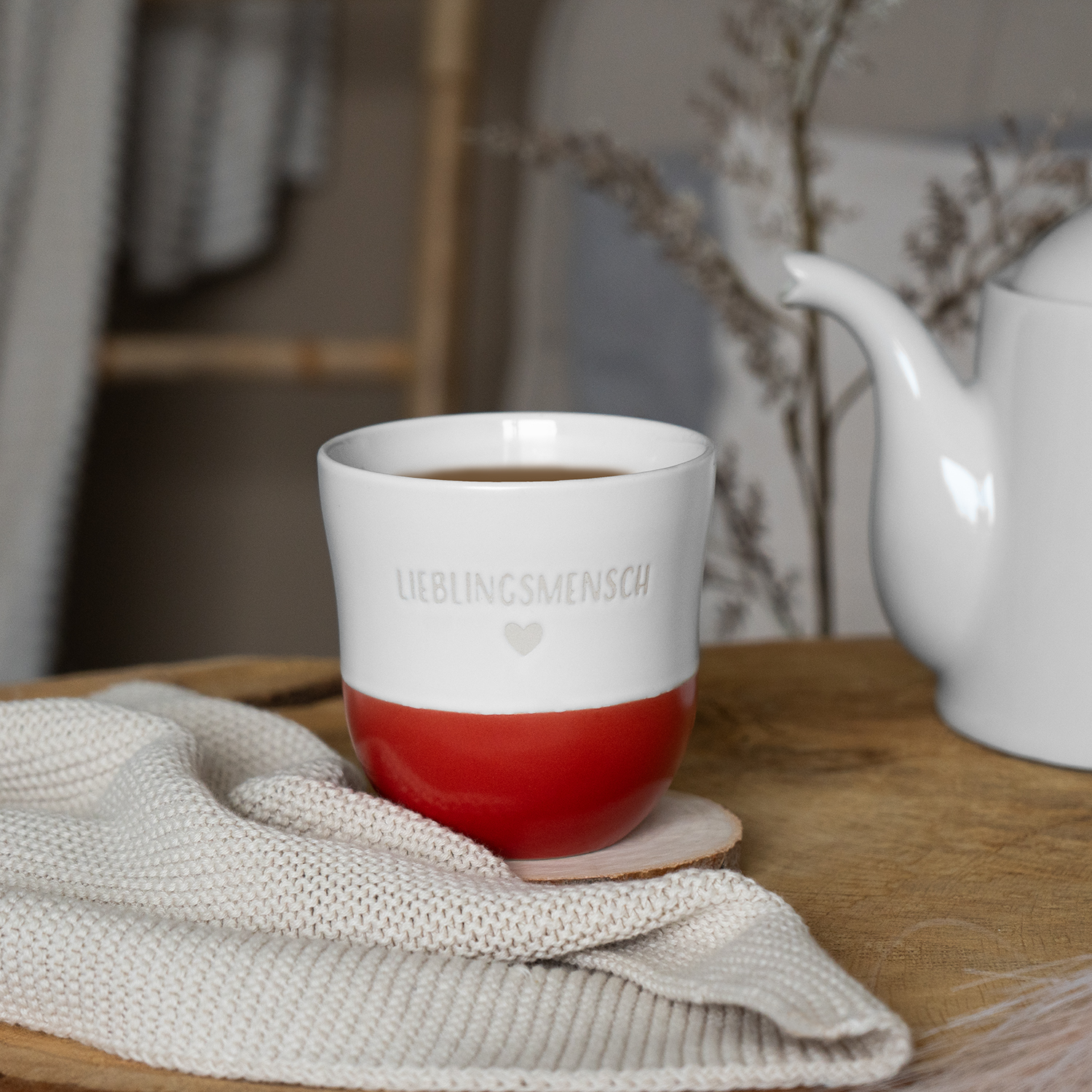 Weiße Steinzeug-Tasse mit rotem Boden und Gravur 'Lieblingsmensch'
