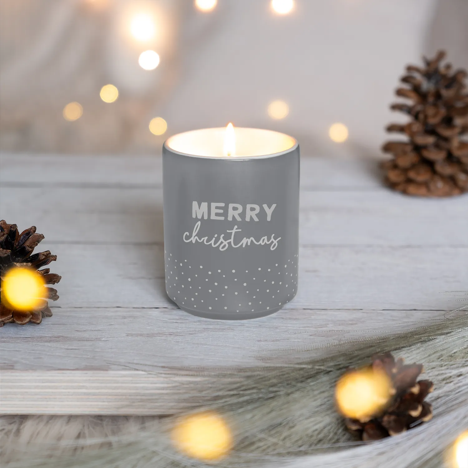 Graue Duftkerze im Porzellan-Behälter mit 'MERRY christmas' Schriftzug und Punktmuster.