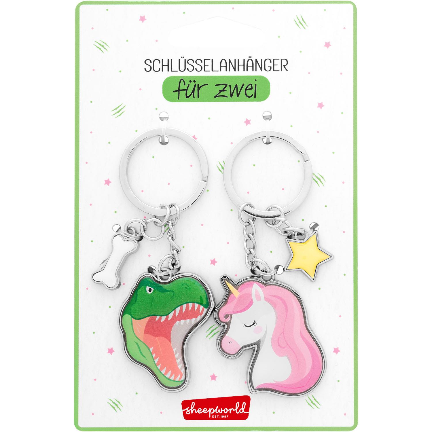 Paar-Schlüsselanhänger Dino und Einhorn aus Metall, mit Ketten, auf Verpackung.