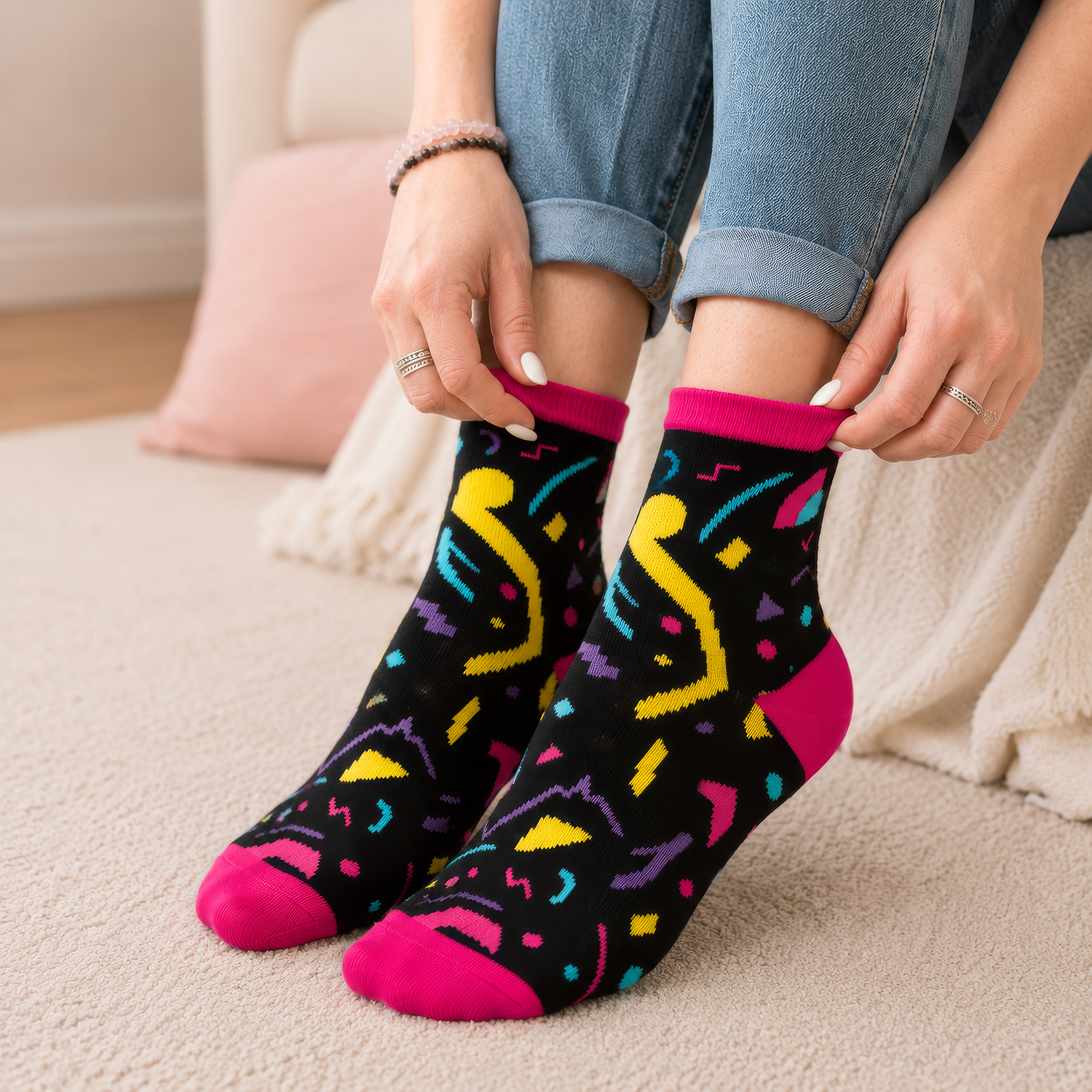 Bunte Zaubersocken mit pinken Spitzen und geometrischem Muster auf schwarzem Hintergrund