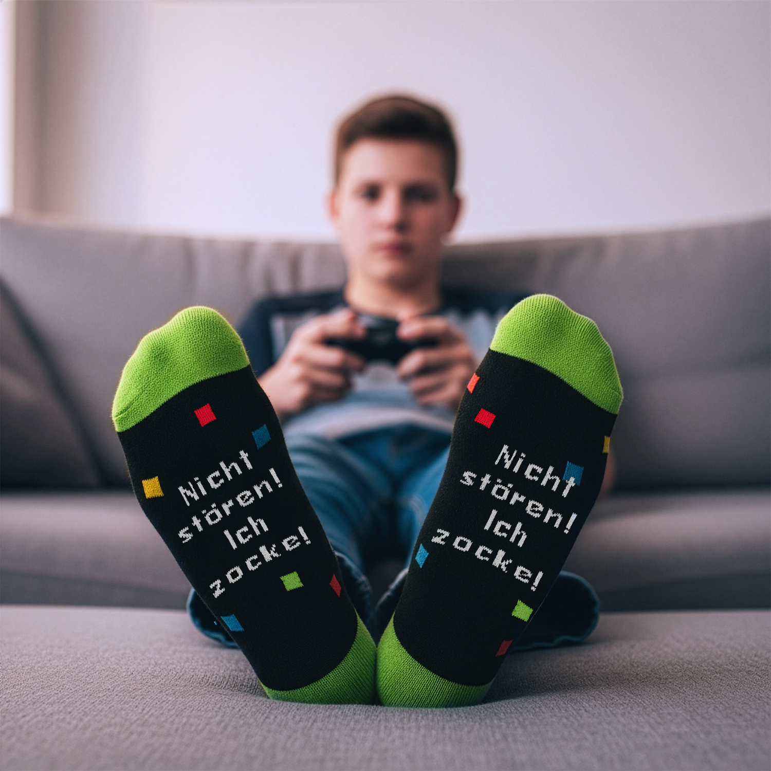 Schwarze Socken mit grünem Rand und dem Spruch 'Nicht stören! ich zocke!'