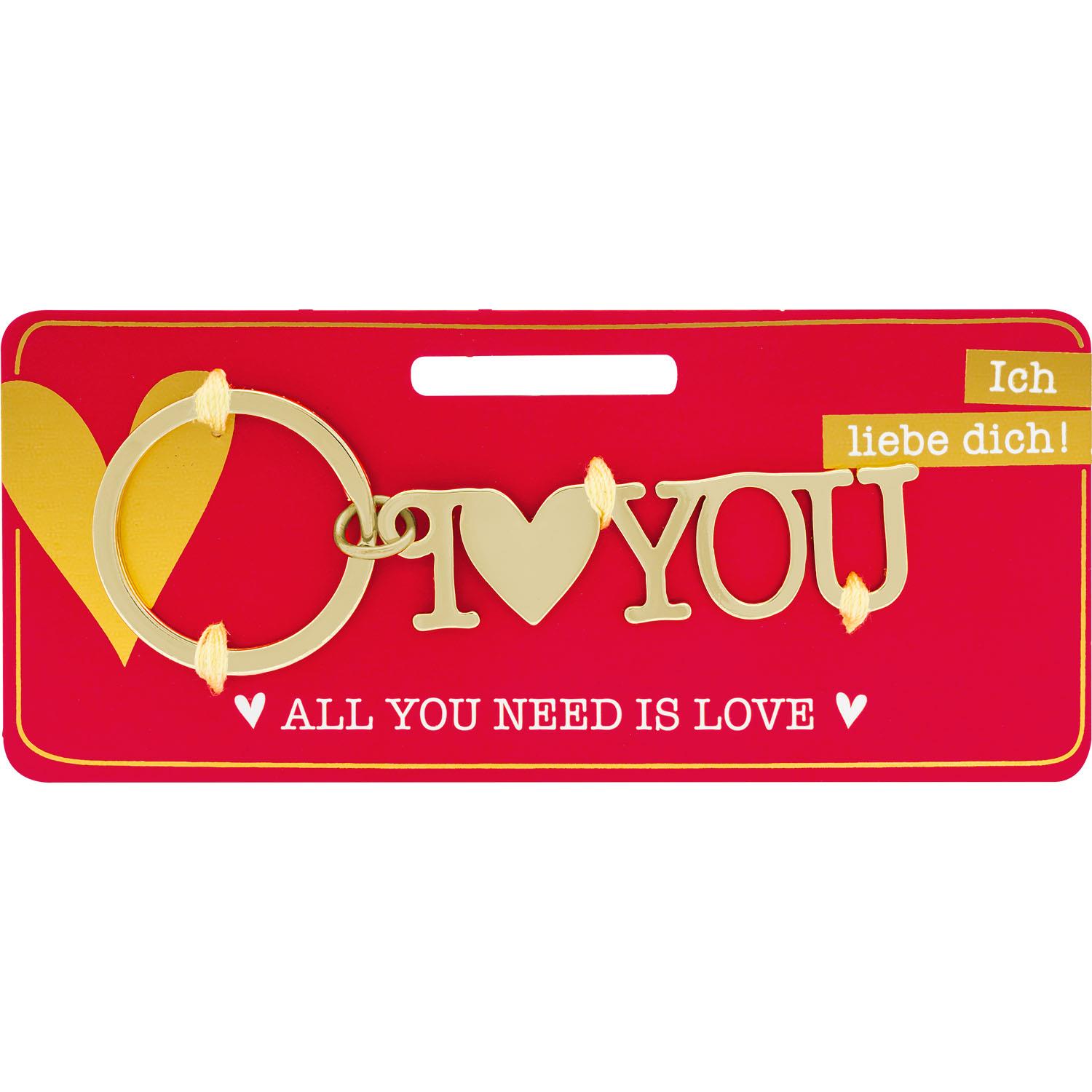 Goldfarbener Schlüsselanhänger mit Herzsymbol und I love you-Schrift auf rotem Werbekarton