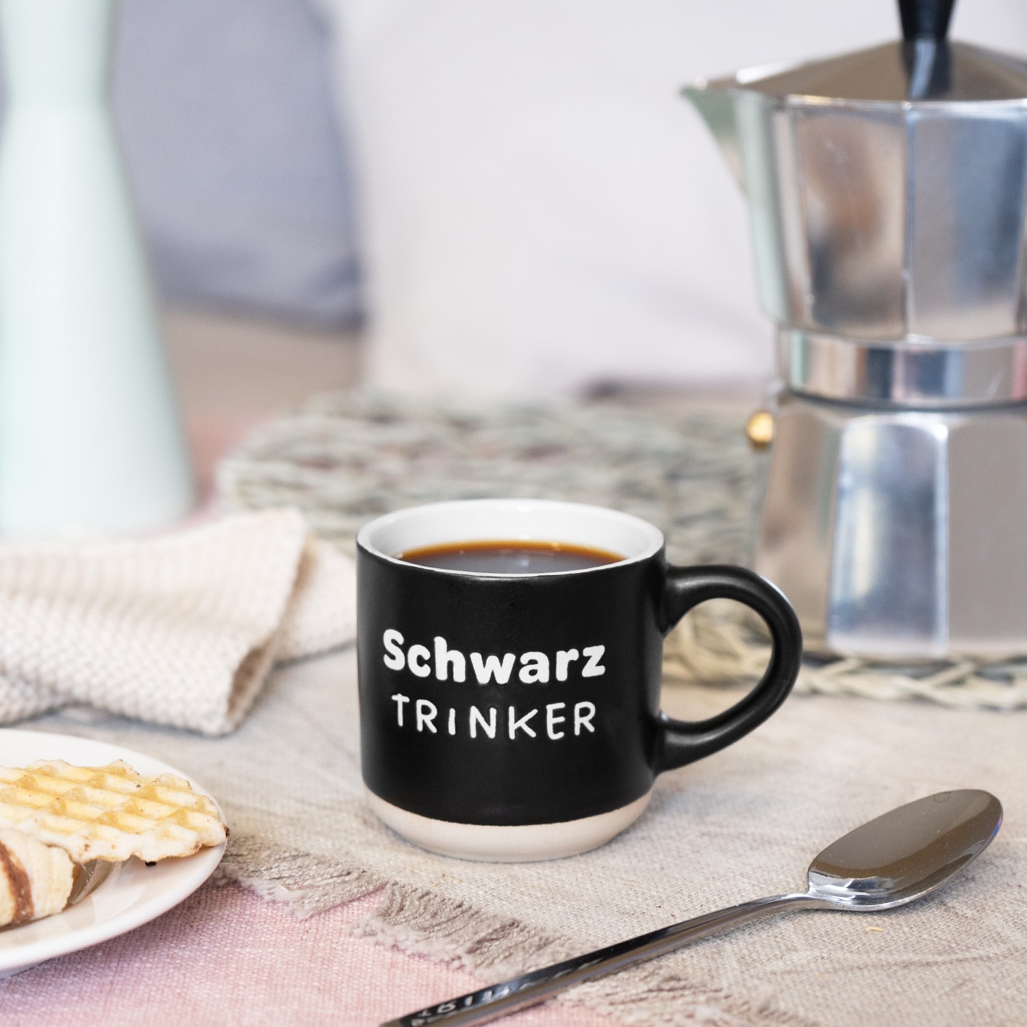 Schwarze Espressotasse mit weißem Innenrand und Schriftzug Schwarztrinker