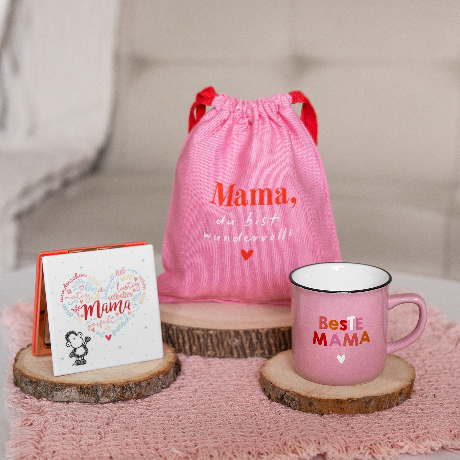 Rosa Muttertags-Geschenkset: Beutel, Becher und Karte auf Holzunterlagen