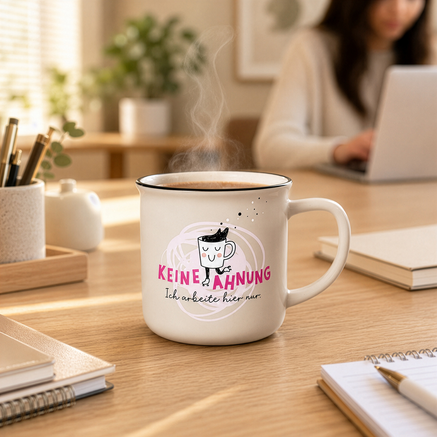 Weiße Keramik-Tasse 'Keine Ahnung' mit pinkem Motiv auf Holzschreibtisch.