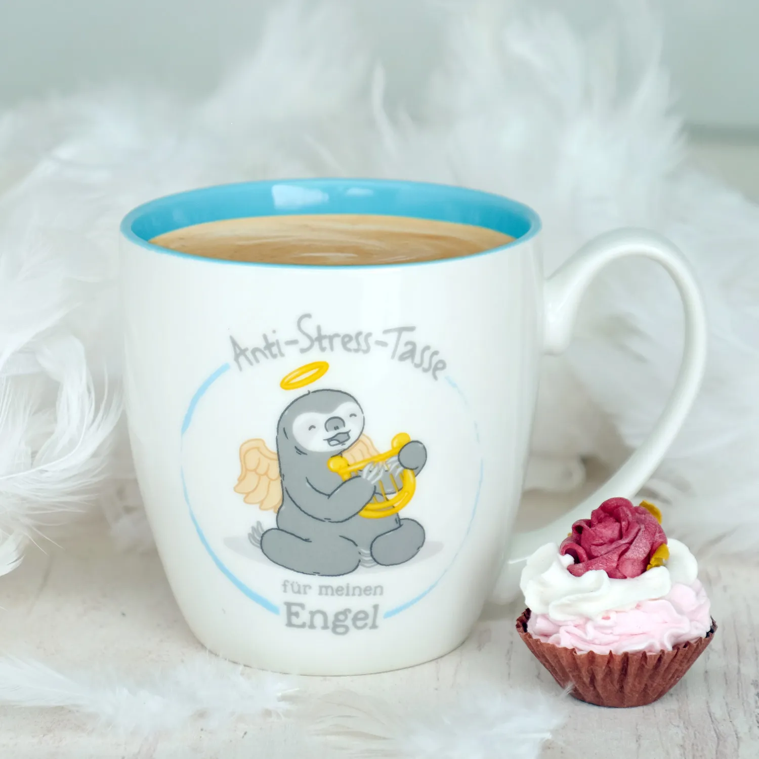 Weiße Bone China Tasse mit hellblauem Innen und Engel-Sloth-Motiv.