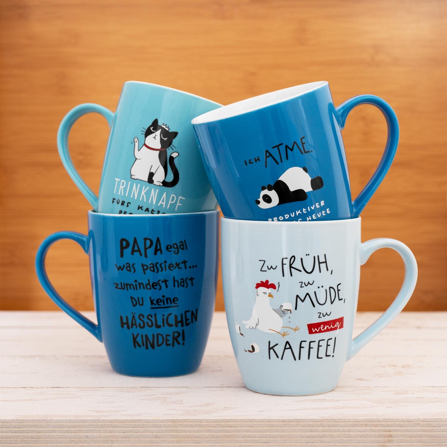 Blauer Porzellan-Becher mit witzigem Papa-Spruch und Cartoon-Motiv.