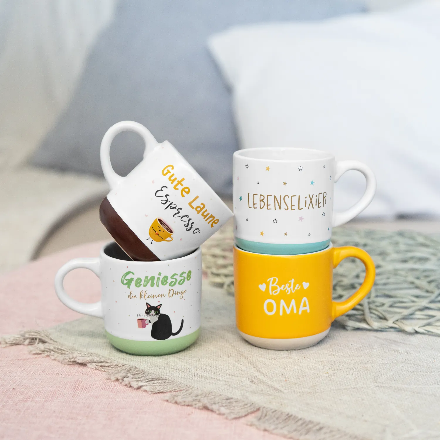 Weiße Espressotasse mit buntem Schriftzug und Motiven auf pastellfarbigem Hintergrund.