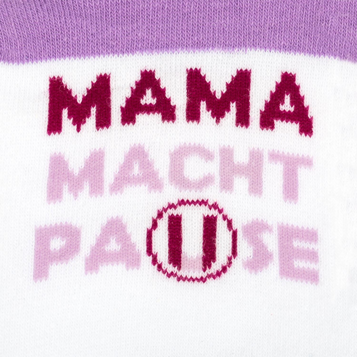 Gestrickte Zaubersocke mit Aufdruck 'Mama macht Pause' in Pink auf Weiß.