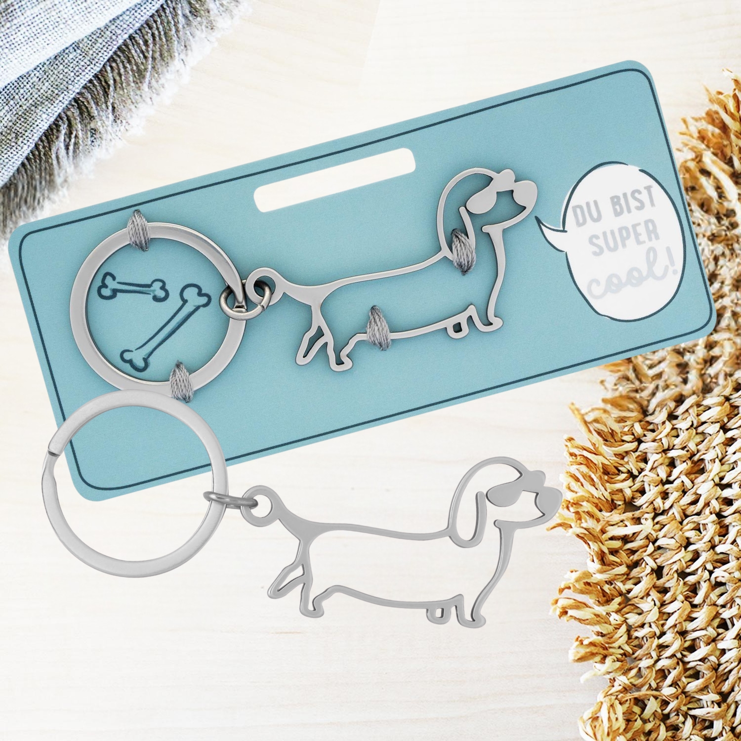 Silberner Dackel-Schlüsselanhänger mit Knochenring-Illustration
