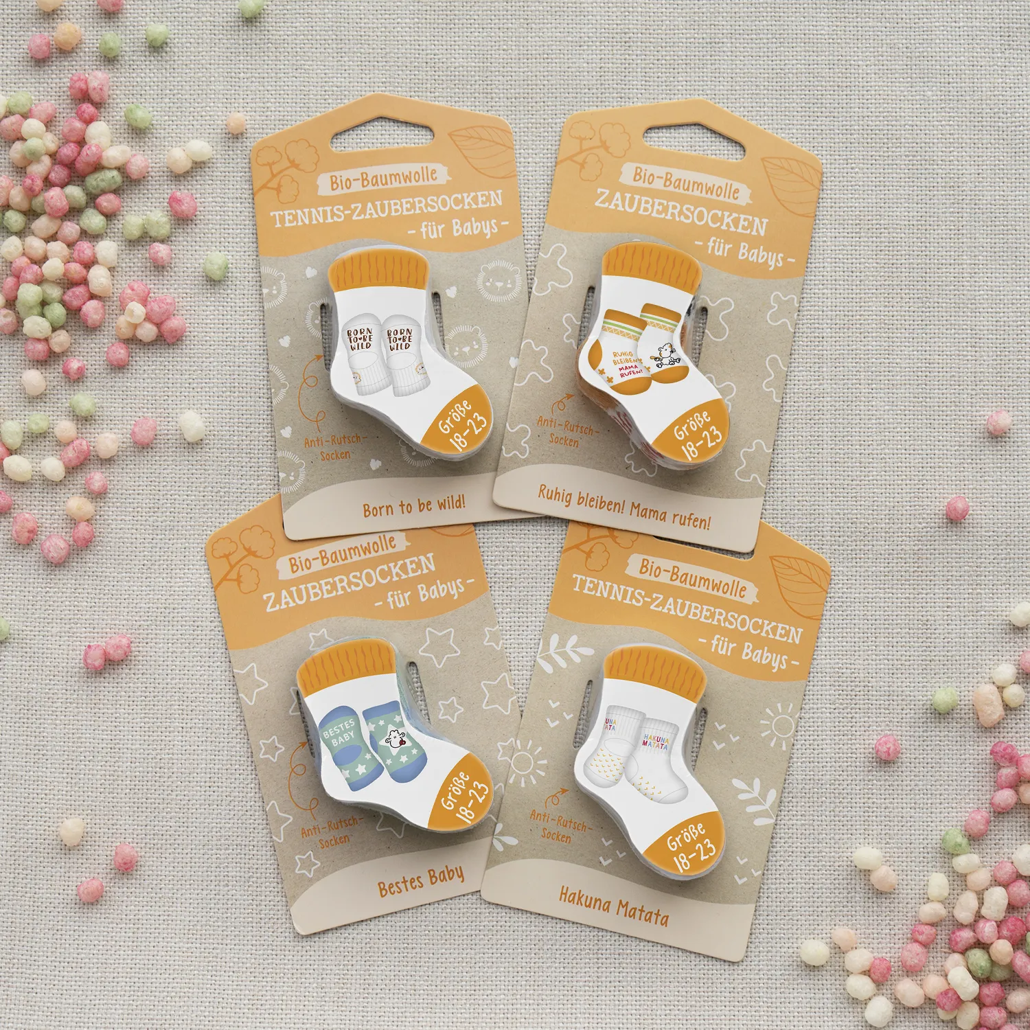 Vier Paar Zaubersocken für Babys in braun-orangen Verpackungen auf Kartonaufhängern