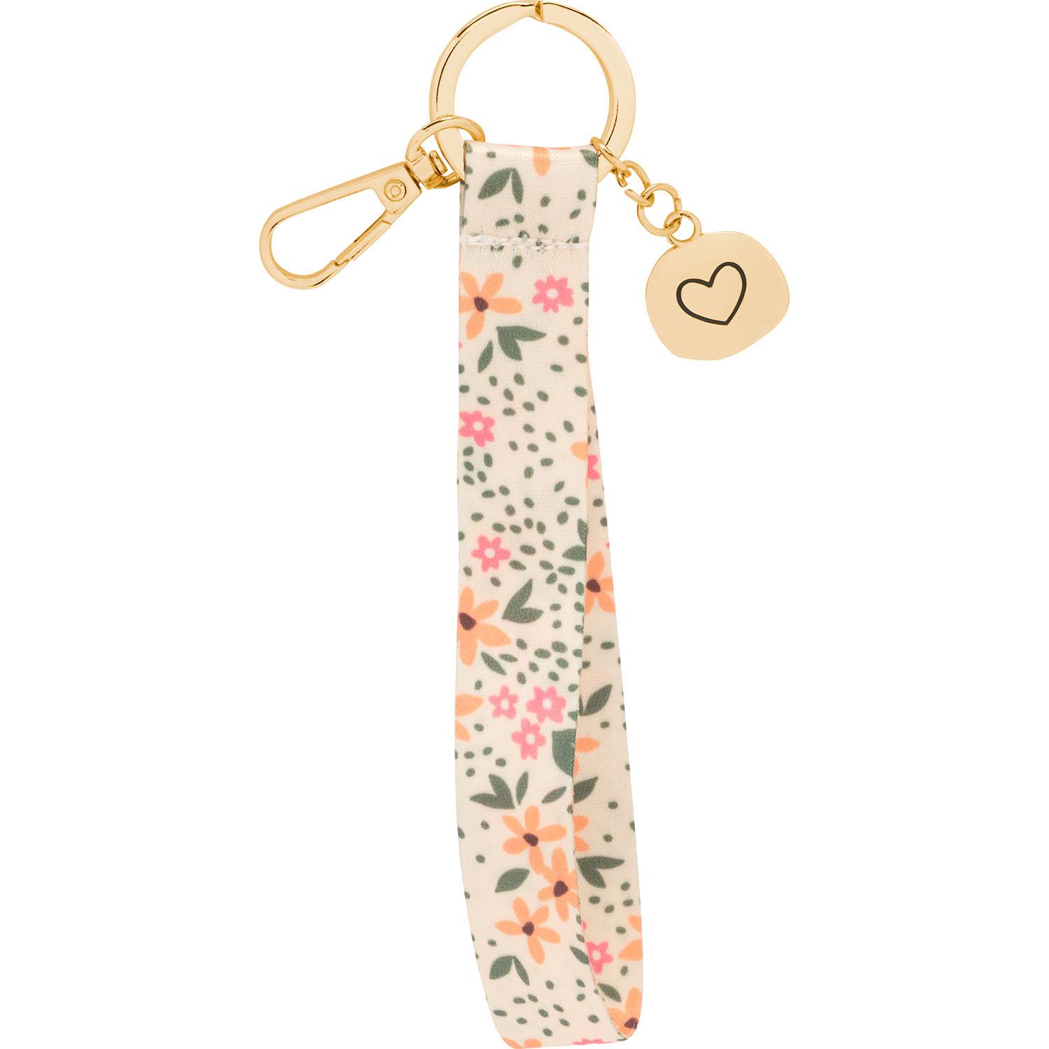 Schlüsselband mit Blumenmuster auf cremefarbenem Band, goldener Karabiner und Herz-Anhänger.