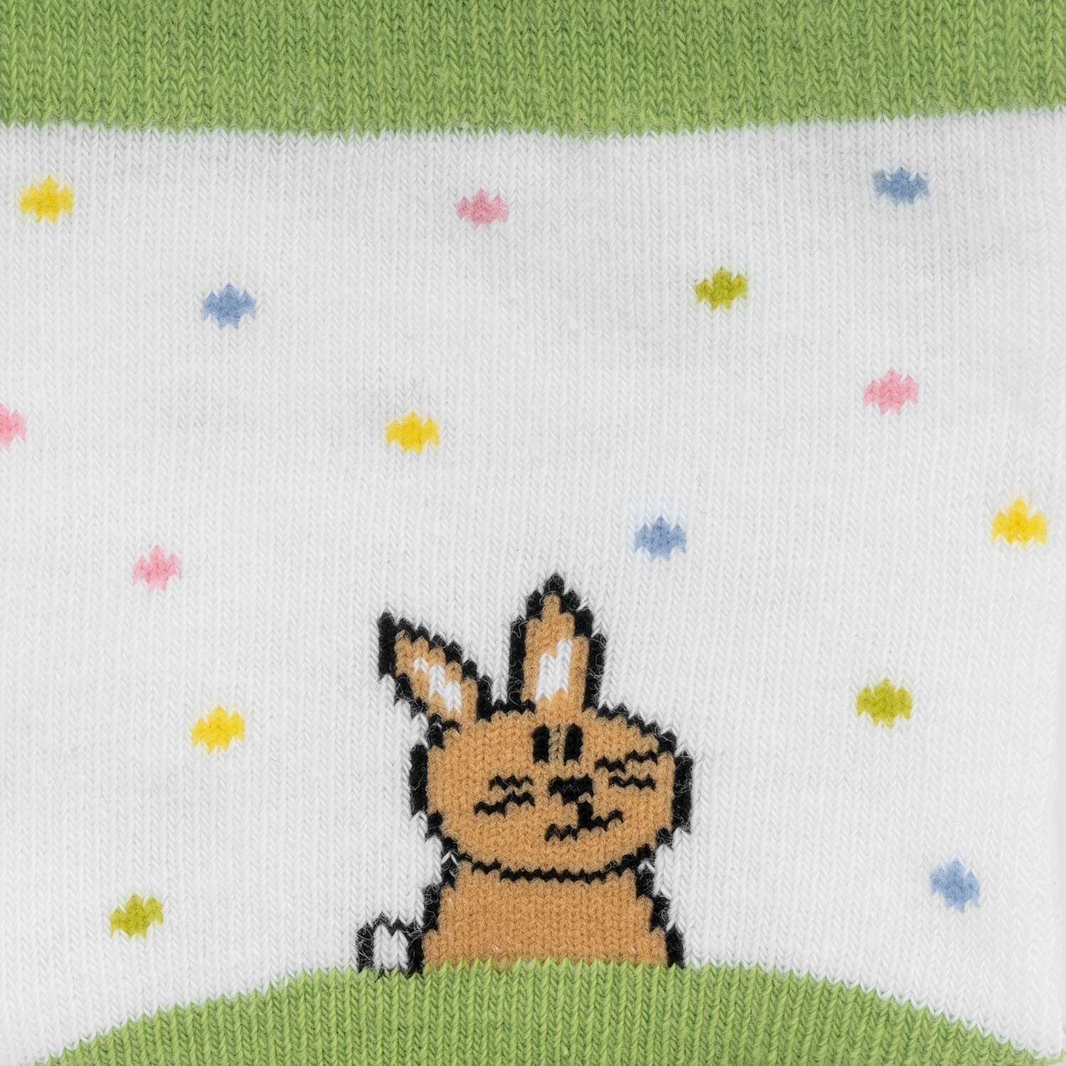 Zaubersocken 'Lieblingshase' – weiße Socke mit grünem Bündchen und Häschen-Motiv auf Gras
