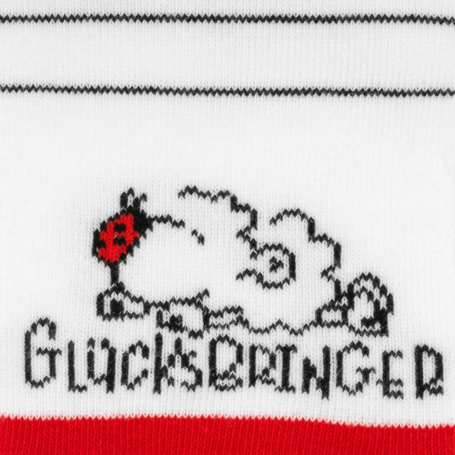 Weiße Socke mit schwarzem Schaf-Motiv und dem Schriftzug Glücksbringer, roter Rand unten.