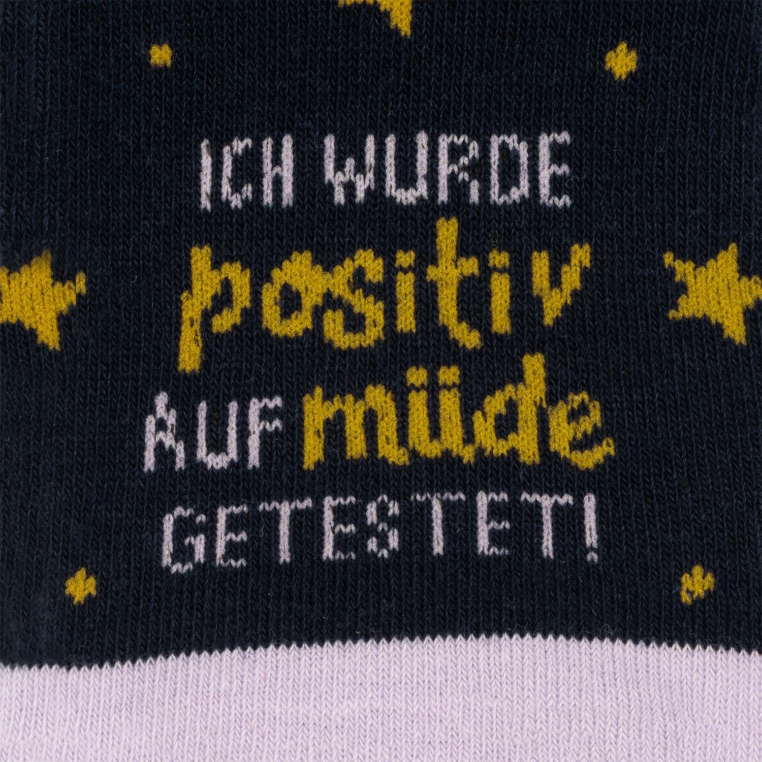 Dunkelblaue Stricksocke mit gelbem Text und Sternchen