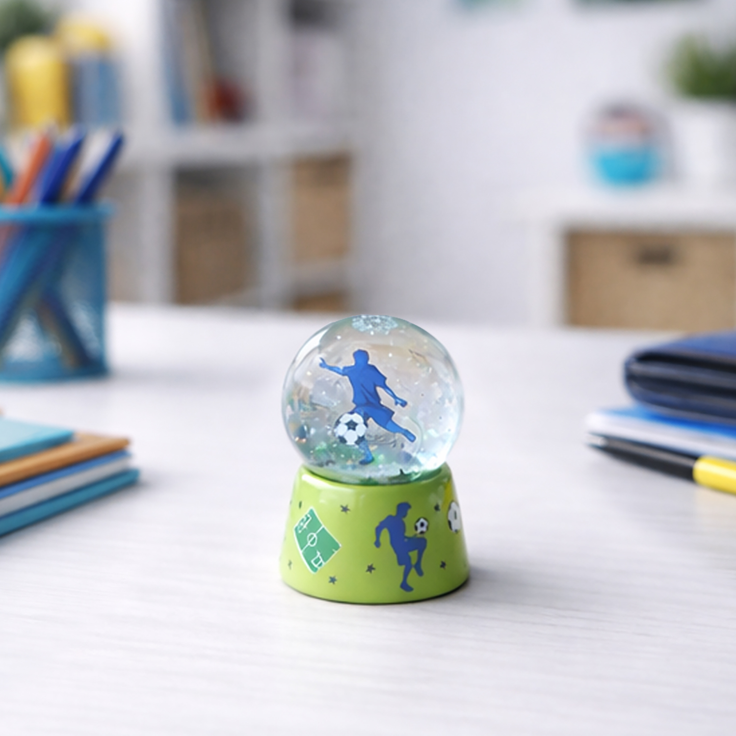 Grüne Traumkugel mit blauer Fußball-Silhouette auf grünem Sockel