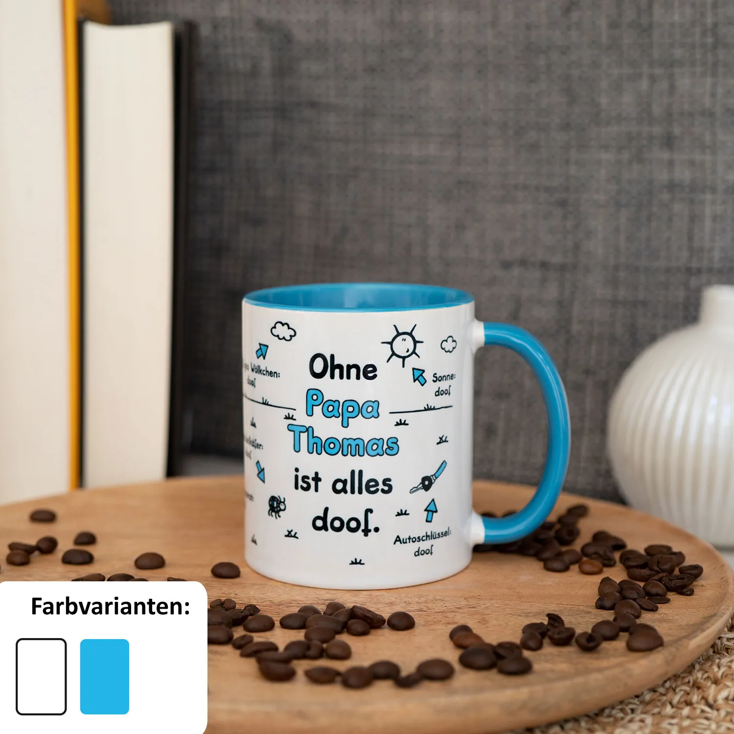 Weiße Porzellans-Tasse mit blauem Henkel und dem Spruch 'Ohne Papa Thomas ist alles doof'