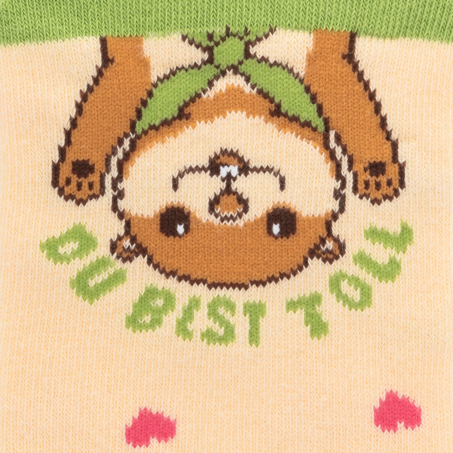 Beige gestrickte Socke mit süßem Schafsgesicht und grünen Blättern – Zaubersocken Du bist toll