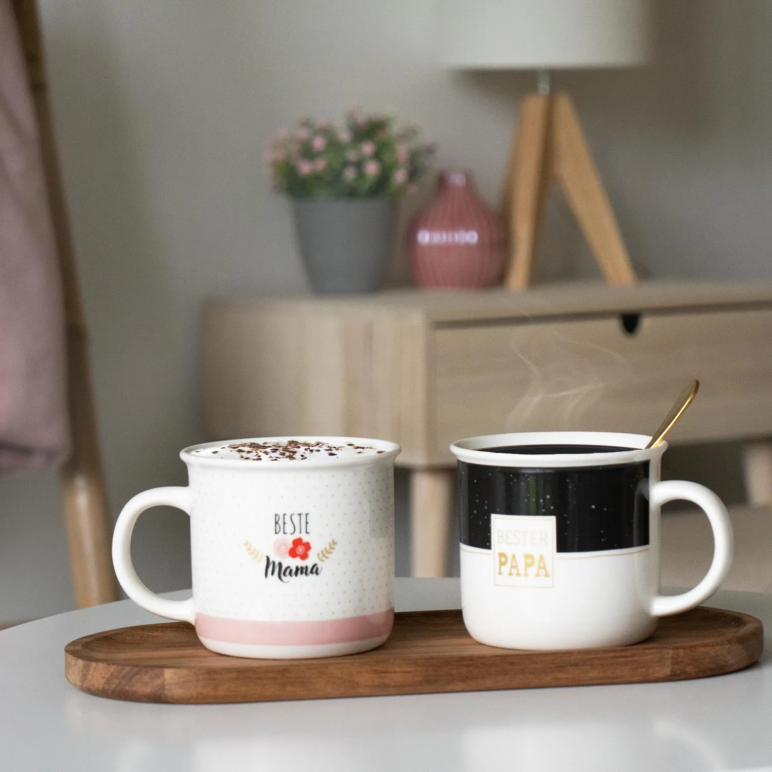 Zwei Porzellan-Becher Beste Mama und Bester Papa auf Holzunterlage