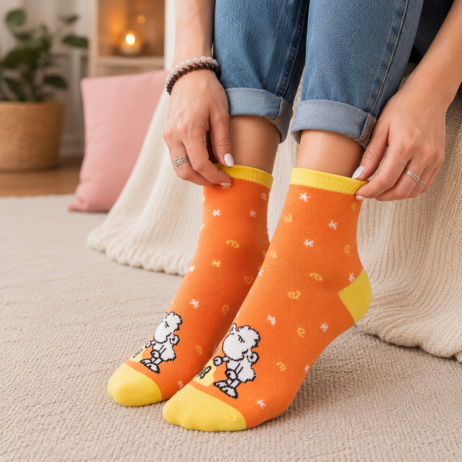 Orangene Zaubersocken mit Schäfchen-Motiv und gelbem Rand, getragen von einer Person.