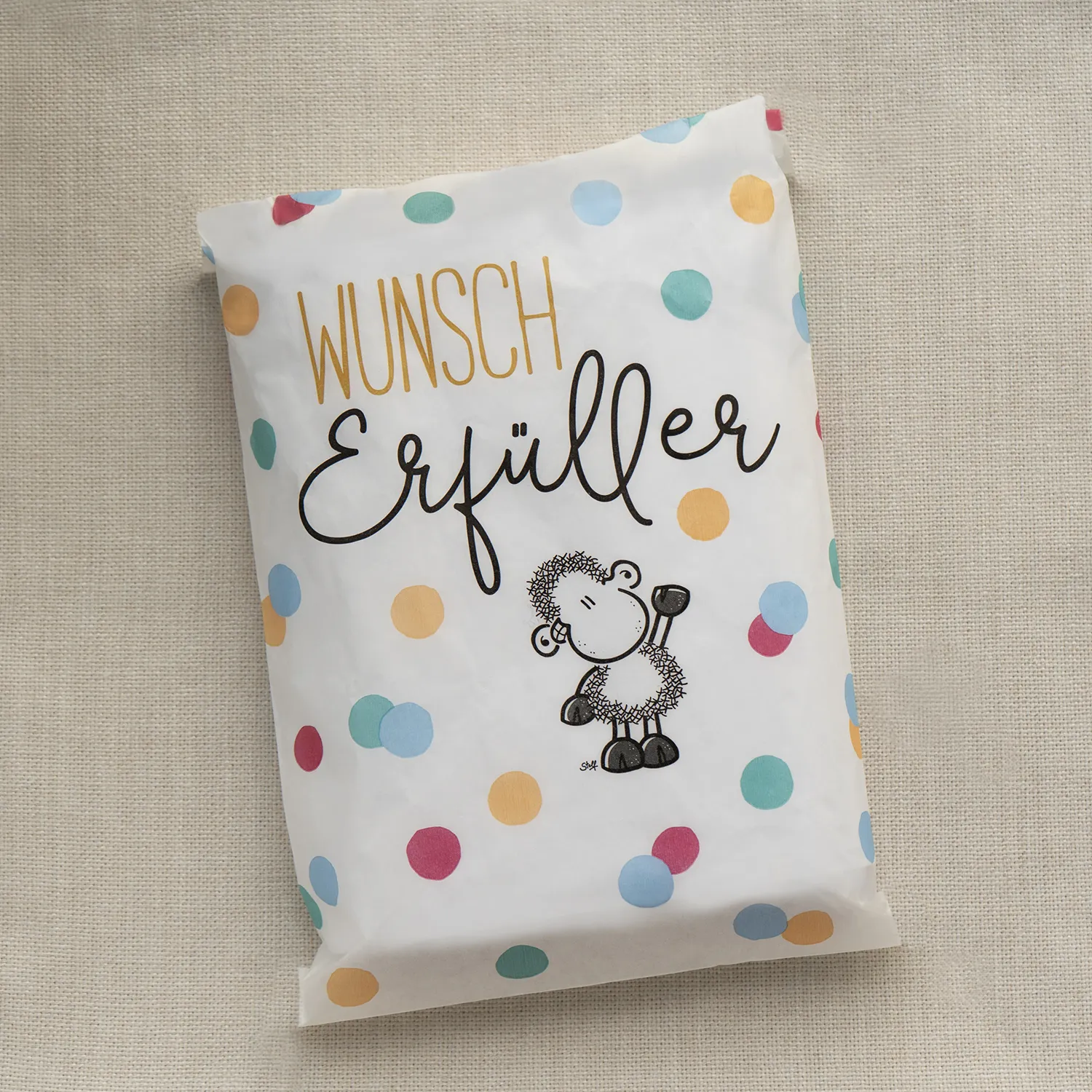 Weiße Verpackung mit bunten Punkten und Schäfchen-Motiv – Zaubersocken-Wundertüte für Babys