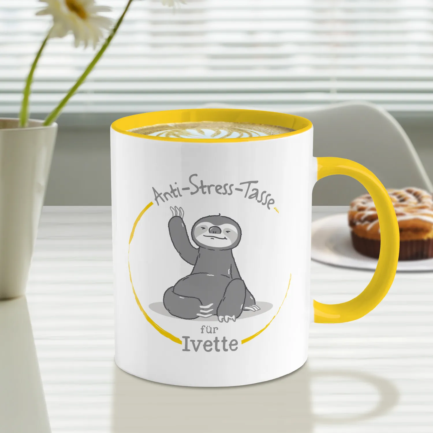 Weiße Porzellan-Tasse mit gelber Innen- und Henkelfarbe und Faultier-Motiv im Kreis