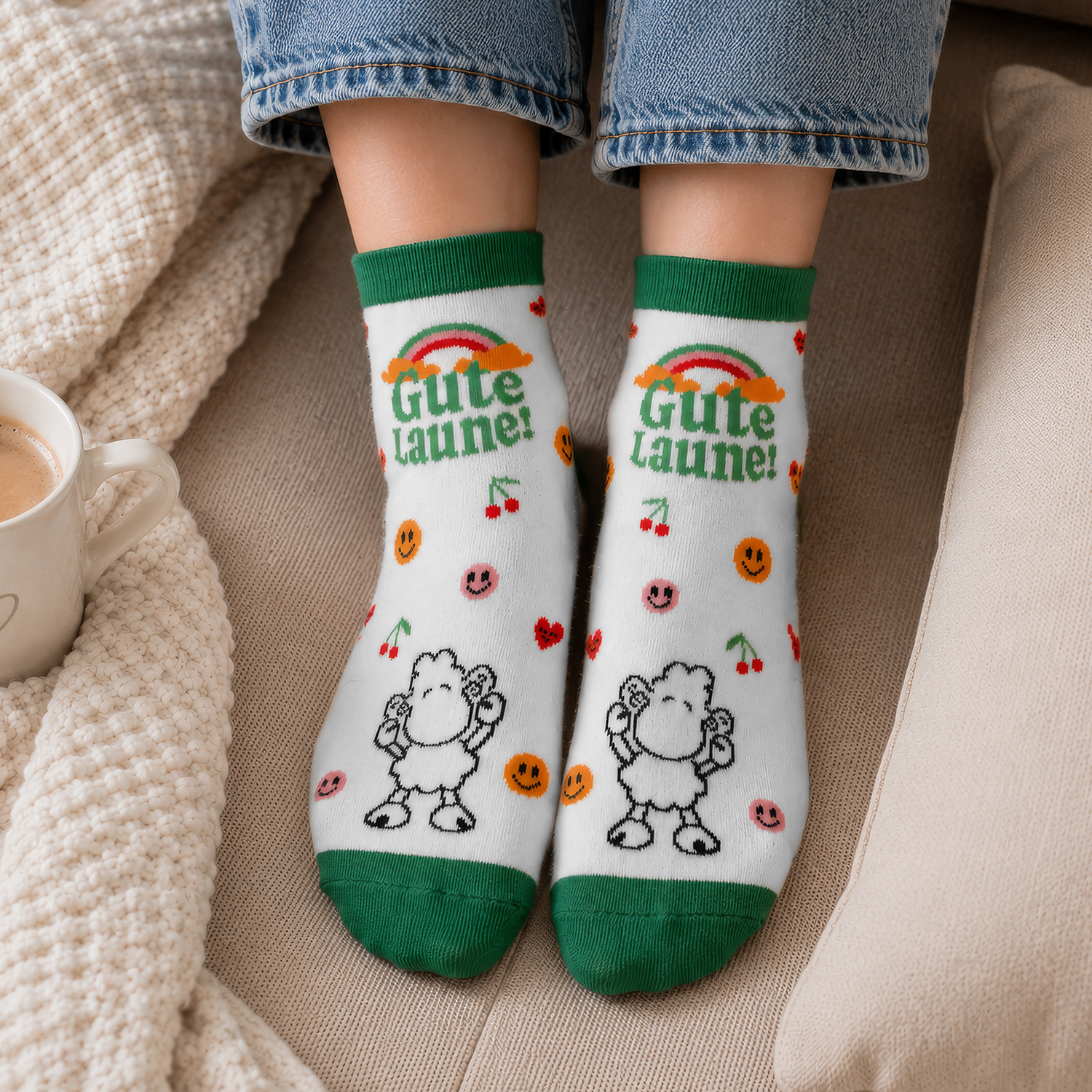 Weiße Socken mit grünem Rand und buntem Motiv 'Gute Laune!' Regenbogen, Schäfchen.