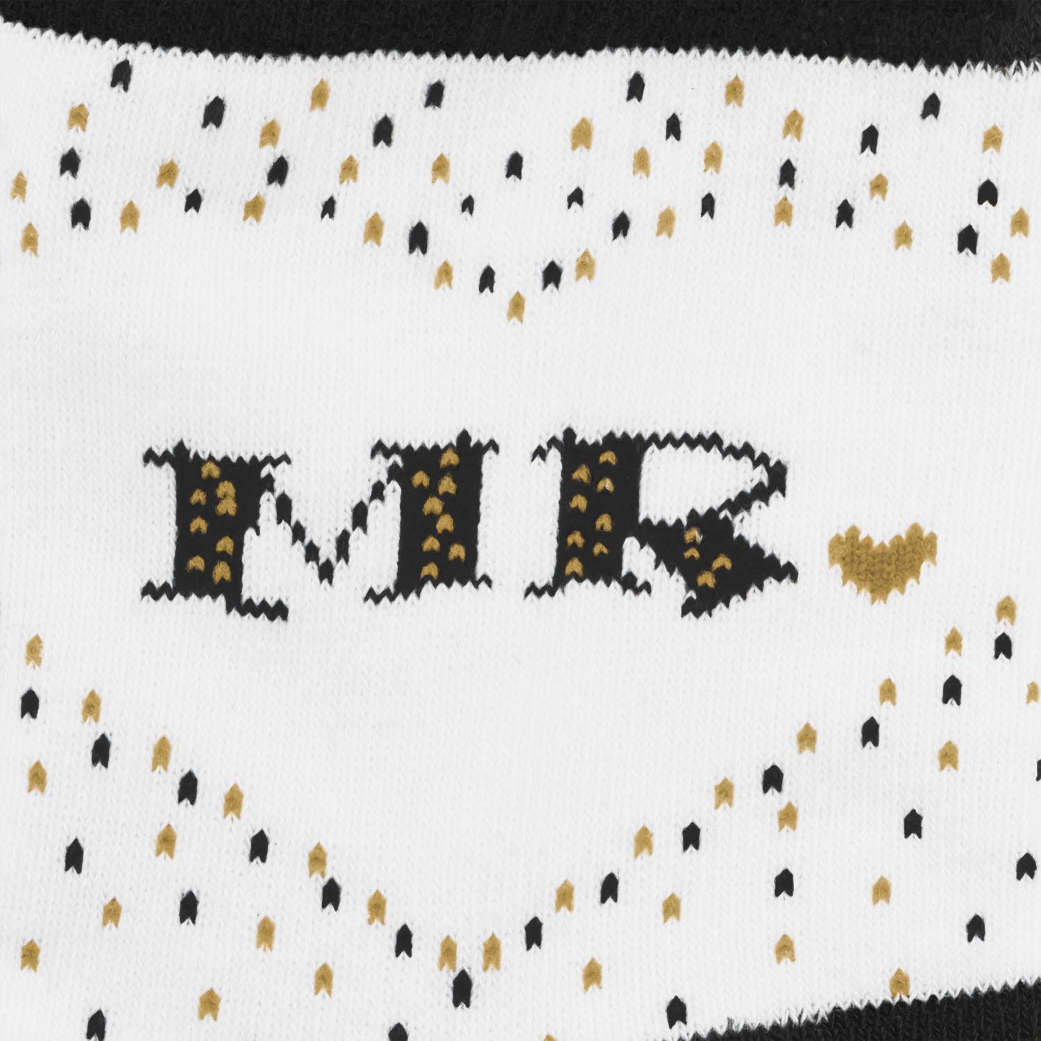 Weiße Zaubersocken mit schwarzem MR-Schriftzug und goldenen Punkten.