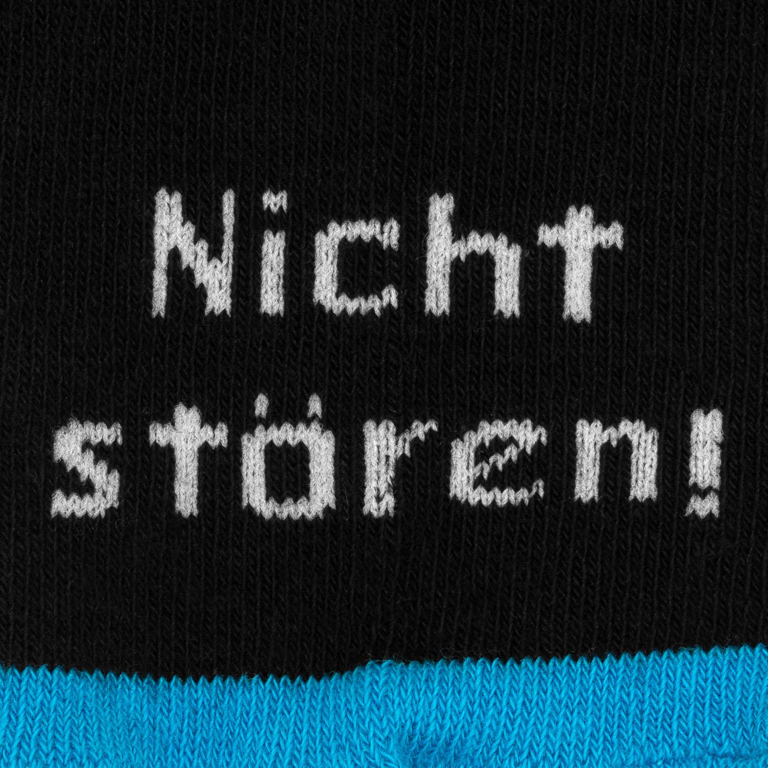 Schwarze Socke mit weißem Schriftzug 'Nicht stören, ich zocke' und blauem Rand