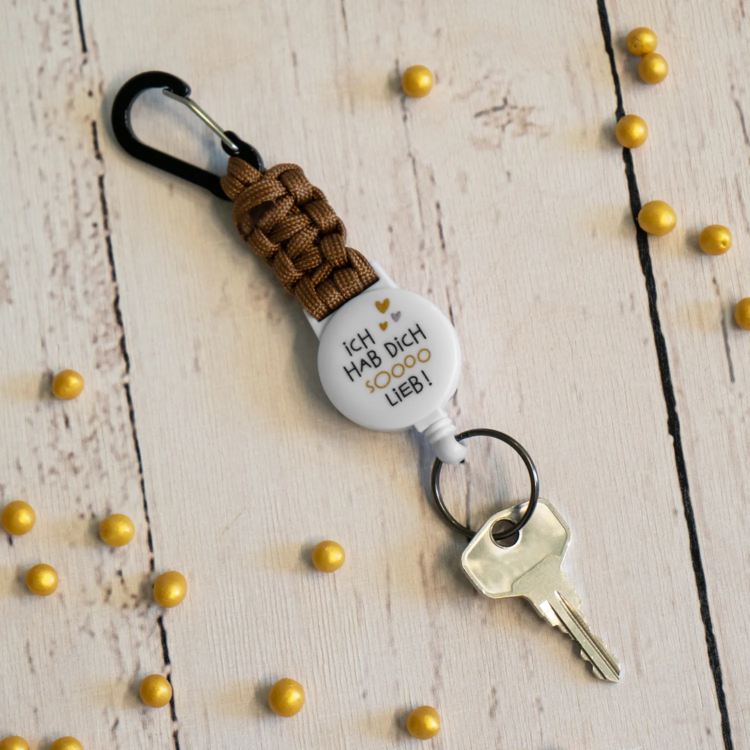 Weißer runder Schlüsselanhänger mit Liebes-Spruch und braunem Paracord