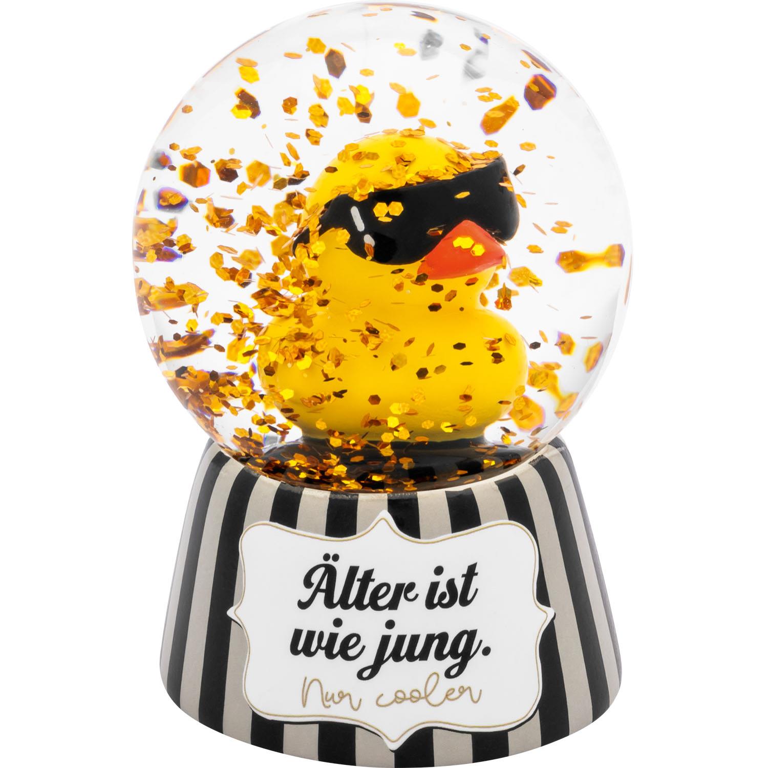 Gelbe Ente in Glaskugel mit Sonnenbrille und Glitzer, auf gestreiftem Sockel
