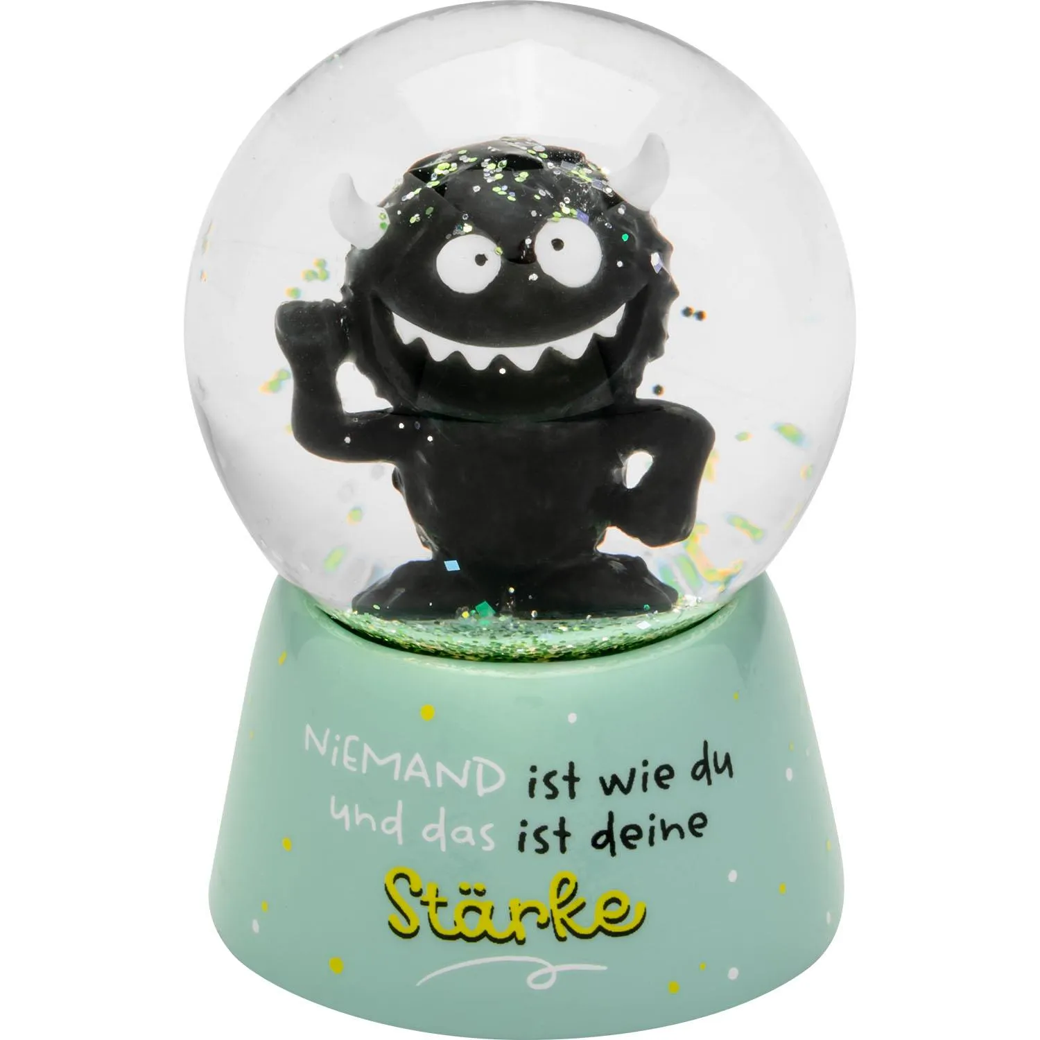 Kleine Glaskugel mit schwarzer Monsterfigur auf pastelgrünem Sockel, Glitzer im Inneren.