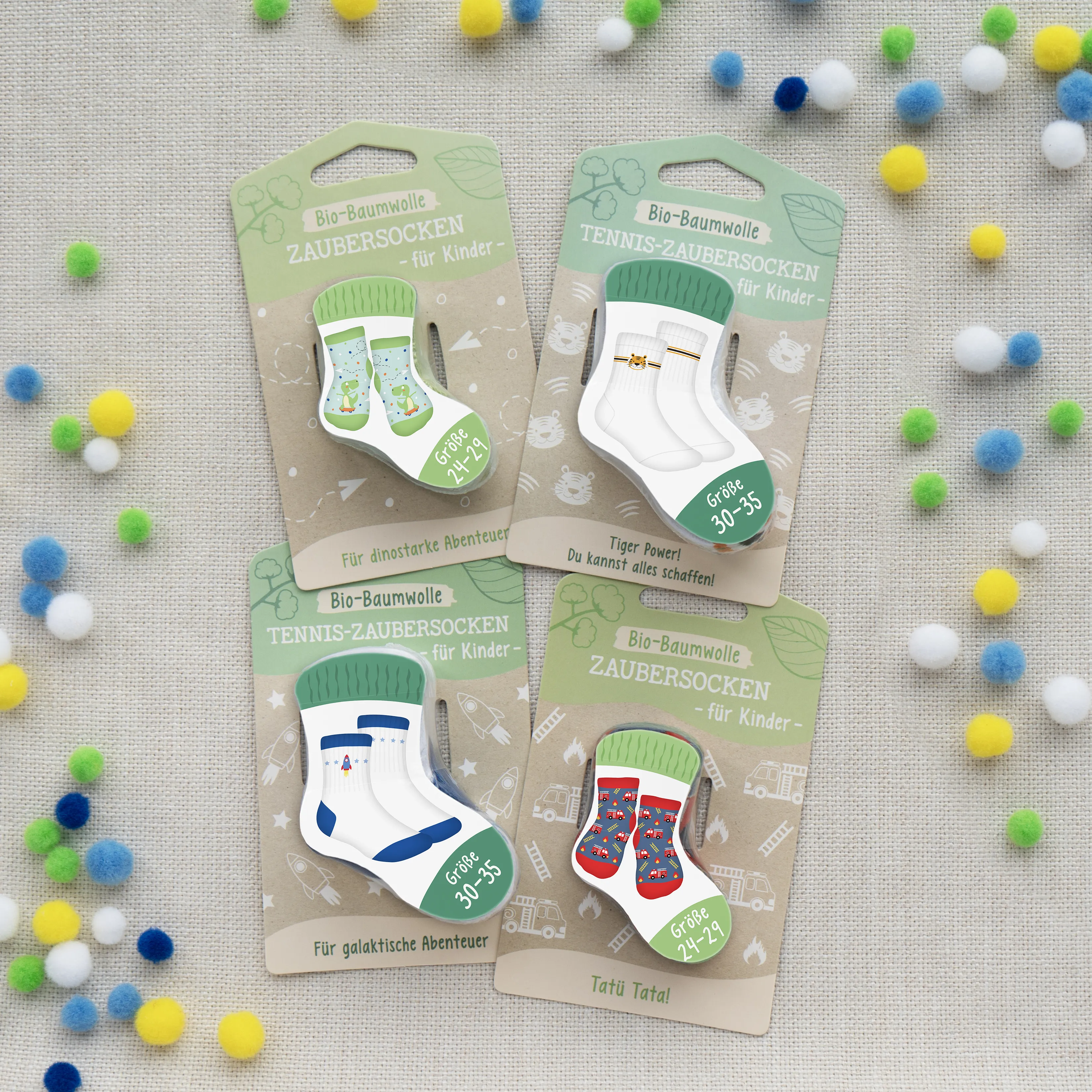 Vier Paar Zaubersocken für Kinder auf Kartonverpackung, bunt mit Tier- und Abenteuer-Motiven