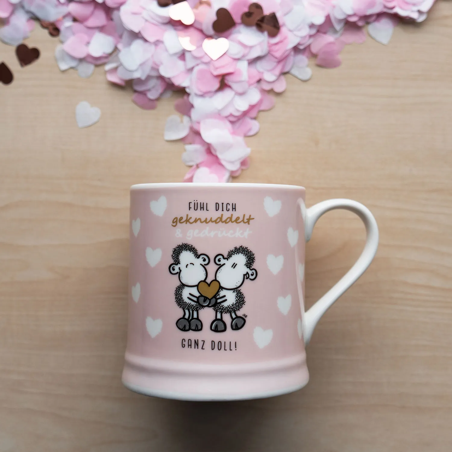 Rosa Porzellan-Tasse mit zwei Schafen, die sich ein Herz geben