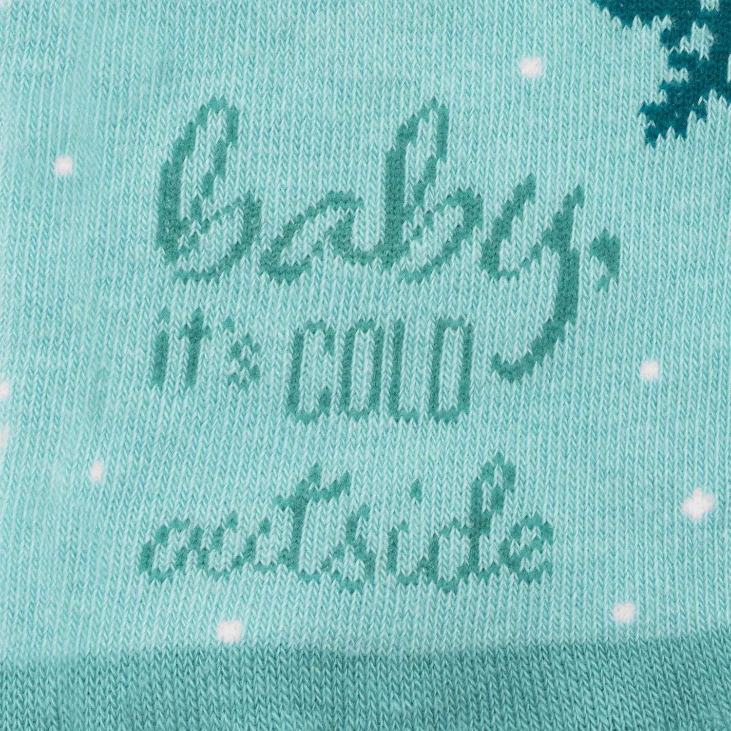 Türkisfarbene Zaubersocken mit Schriftzug 'Baby it's cold outside' und weißen Tupfen.